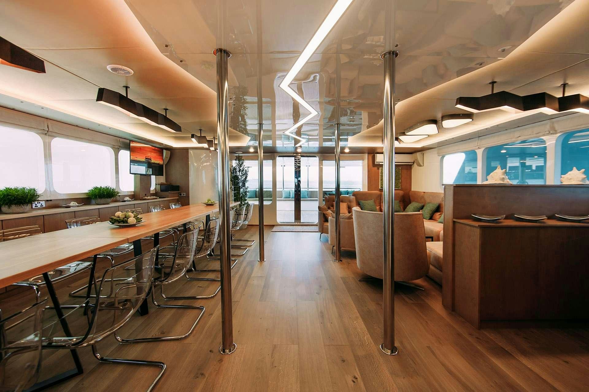 a room with tables and chairs aboard ALICE Yacht for Charter