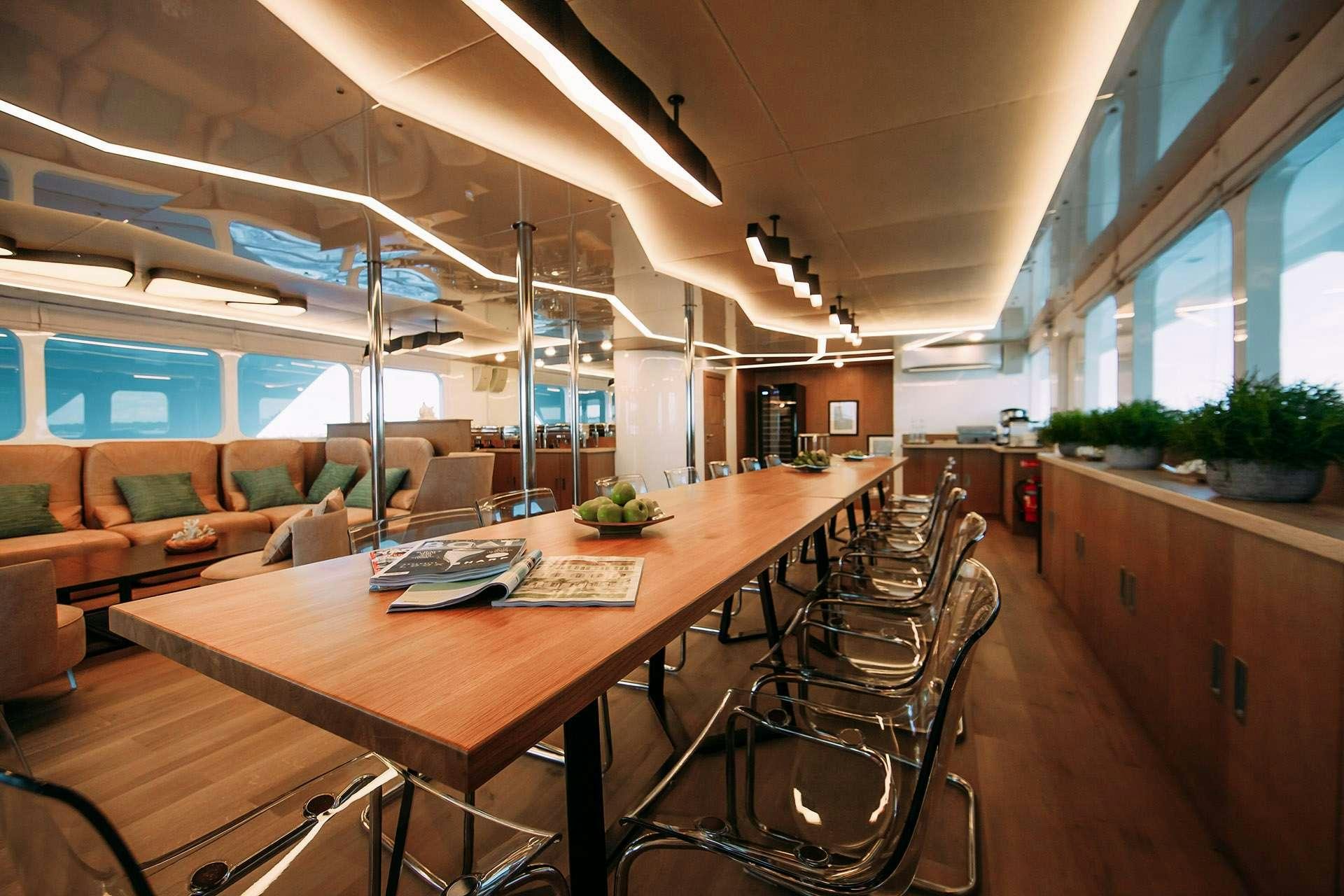 a room with a table chairs and a couch aboard ALICE Yacht for Charter