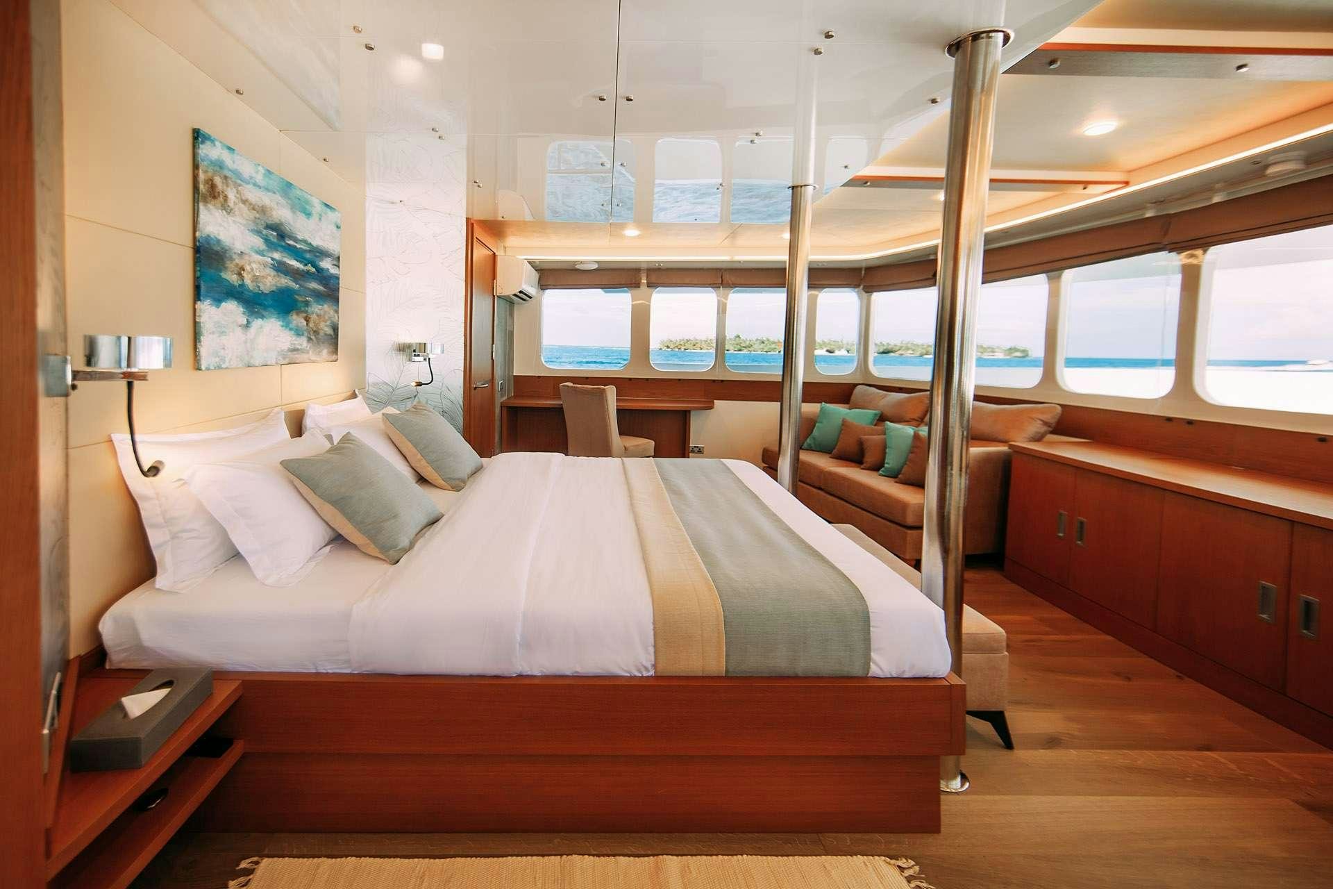 a room with a bed and a desk aboard ALICE Yacht for Charter