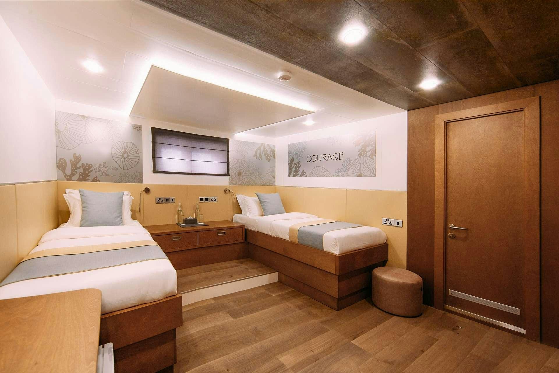 a room with a couple of beds aboard ALICE Yacht for Charter