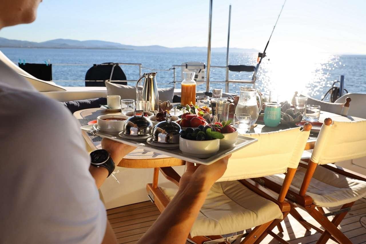a table with food and drinks on it aboard OCEAN MED Yacht for Charter