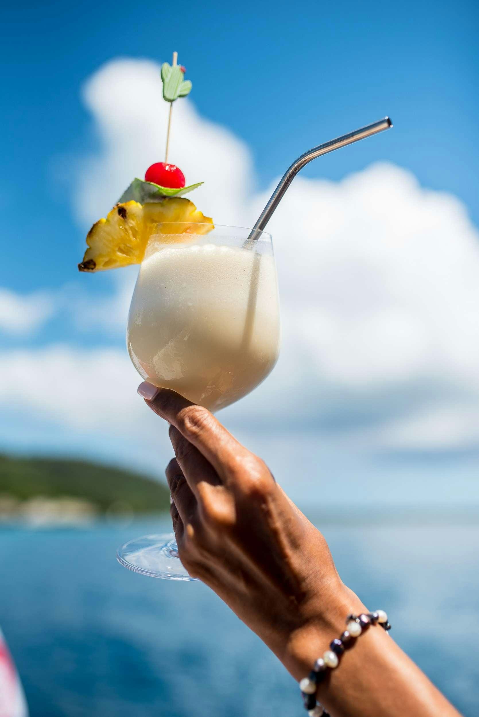 a hand holding a glass with a fruit on it aboard OCEAN VIEW Yacht for Charter