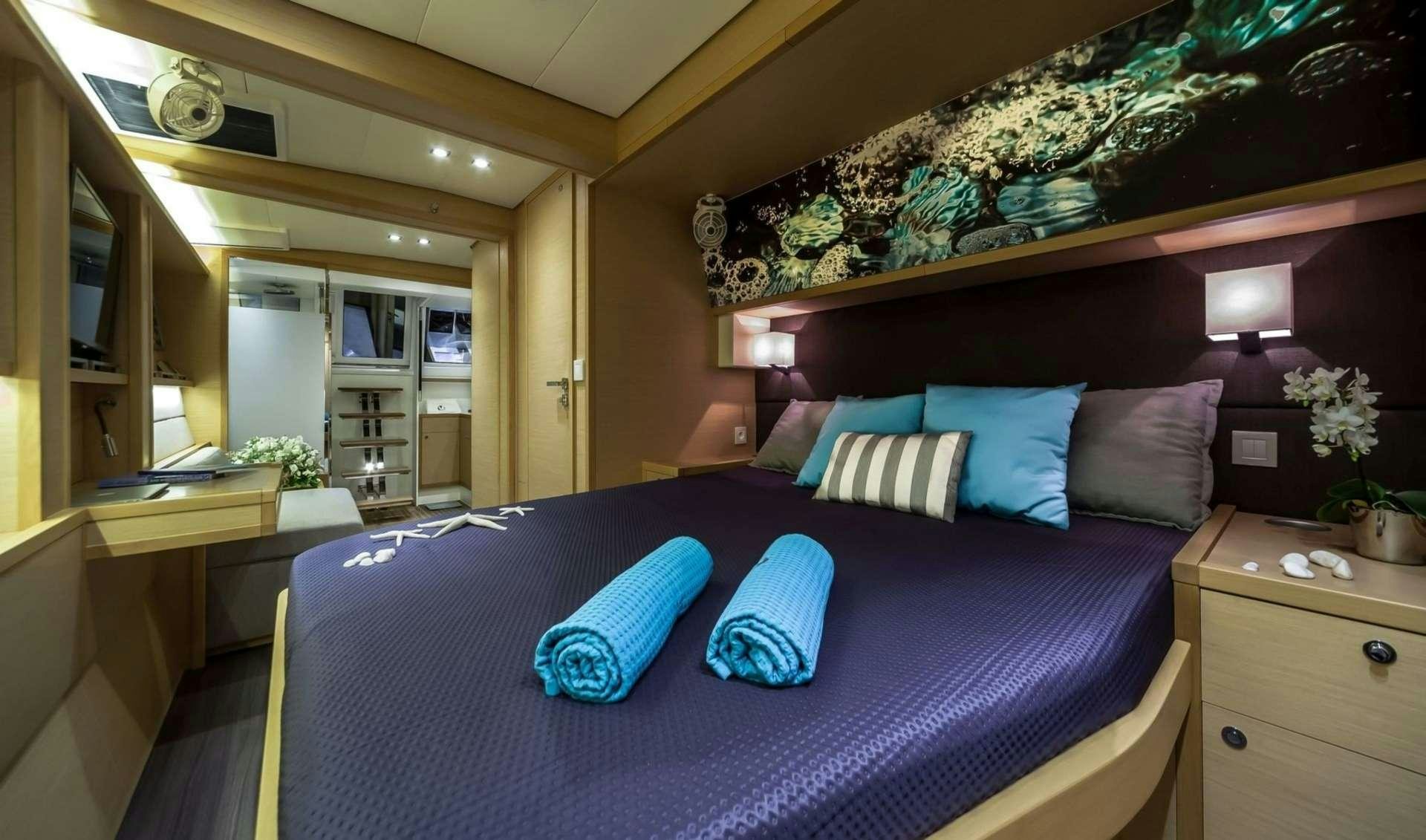 a bed with blue sheets aboard OCEAN VIEW Yacht for Charter