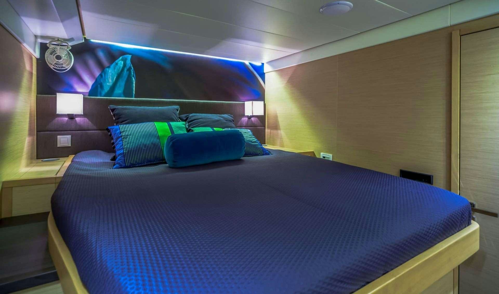 a bed with blue sheets aboard OCEAN VIEW Yacht for Charter