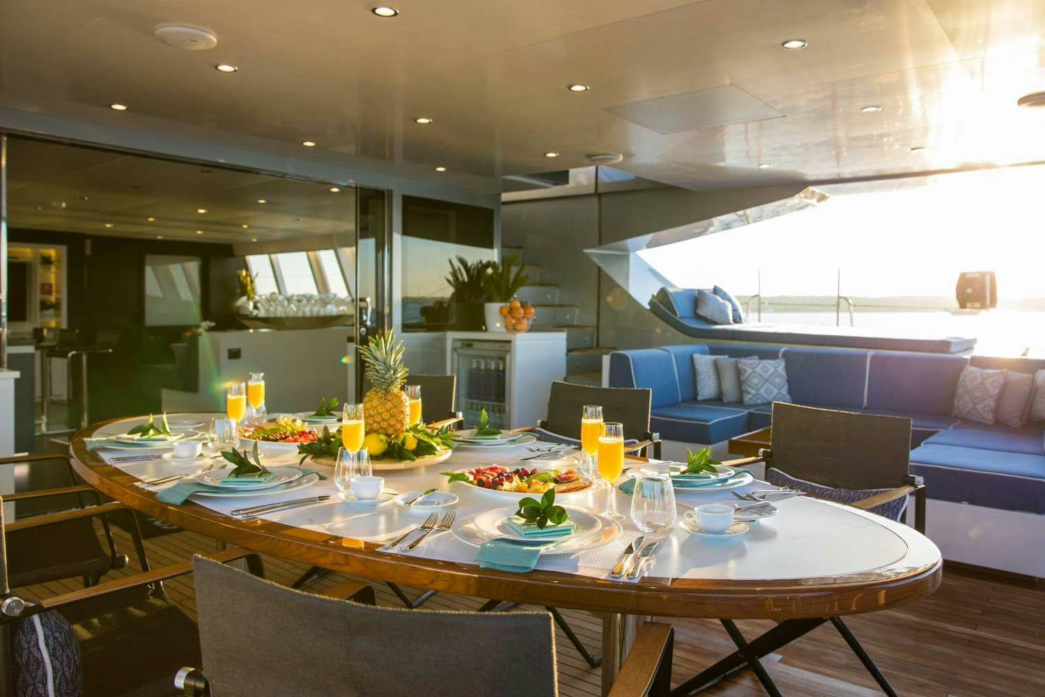 a large dining table in a living room aboard CARTOUCHE Yacht for Charter