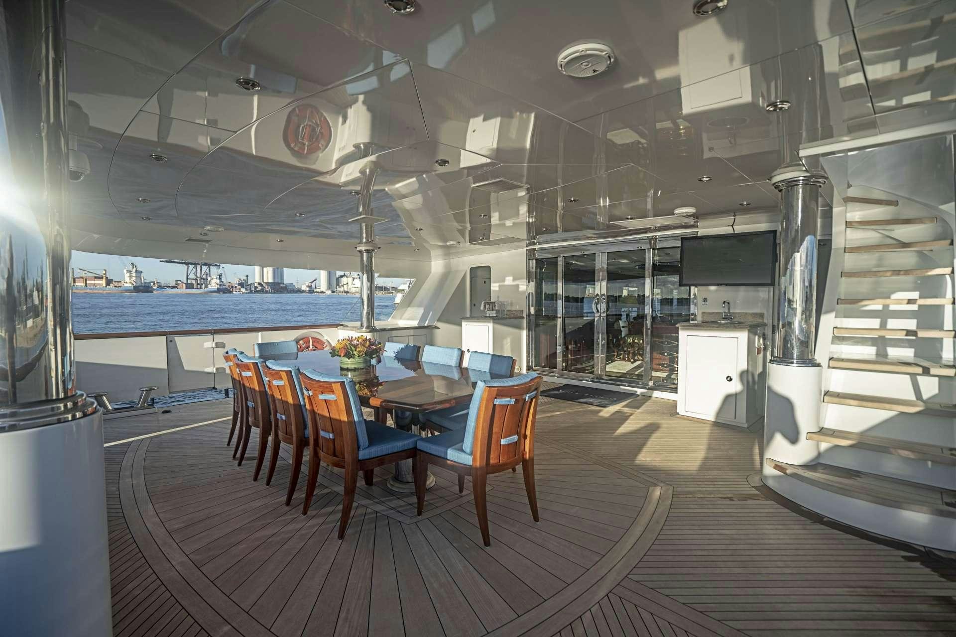 a room with a table chairs and a television aboard MISS CHRISTINE Yacht for Charter