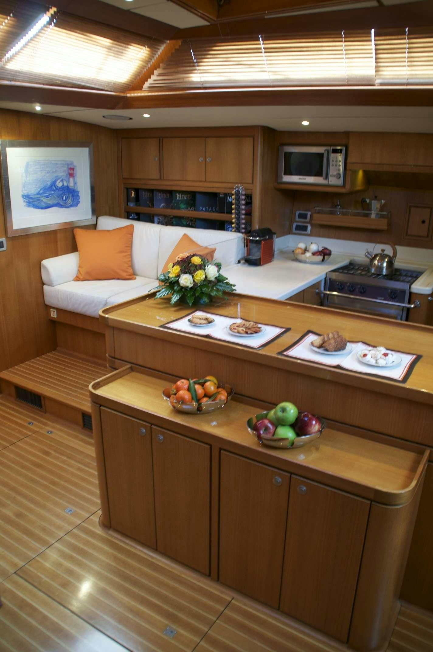 a kitchen with a table and a couch aboard VOLADOR Yacht for Charter