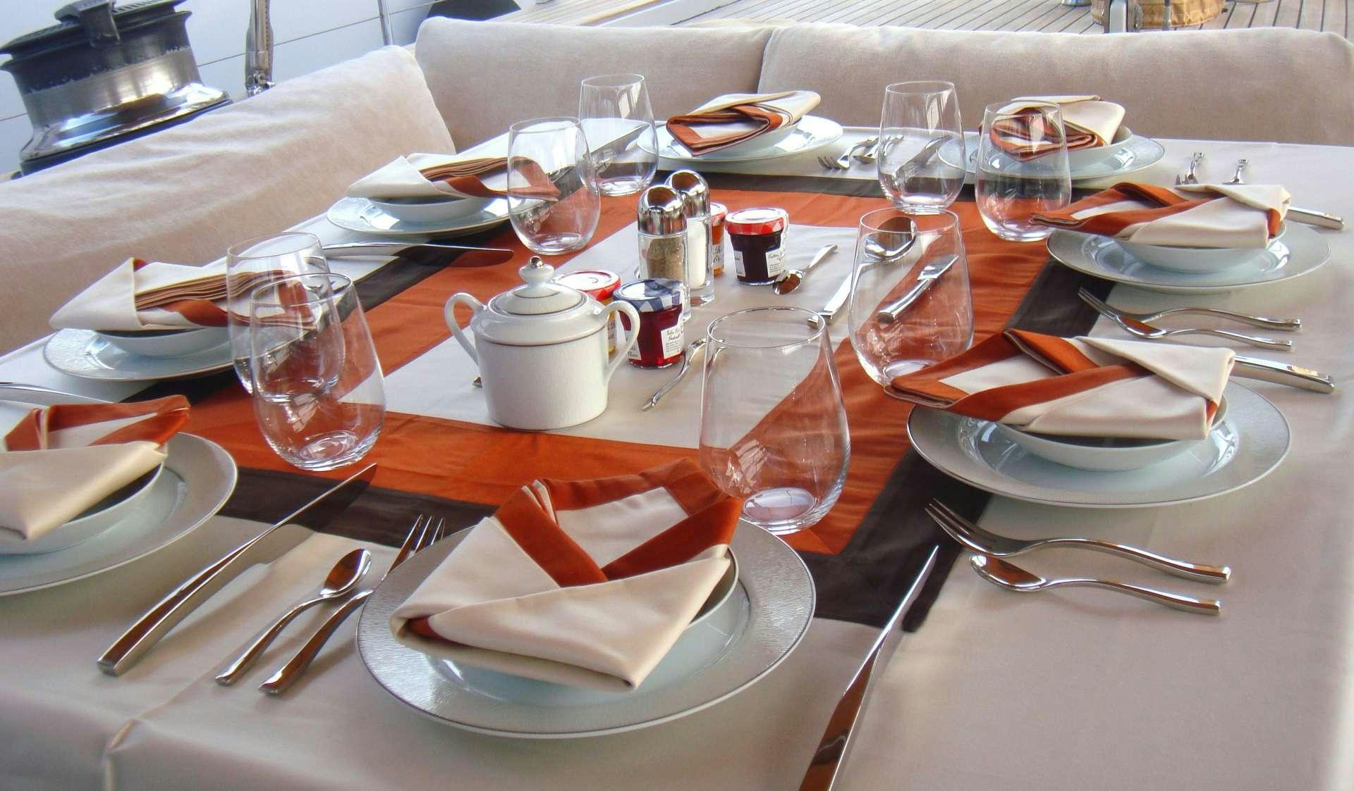 a table with plates and glasses aboard VOLADOR Yacht for Charter