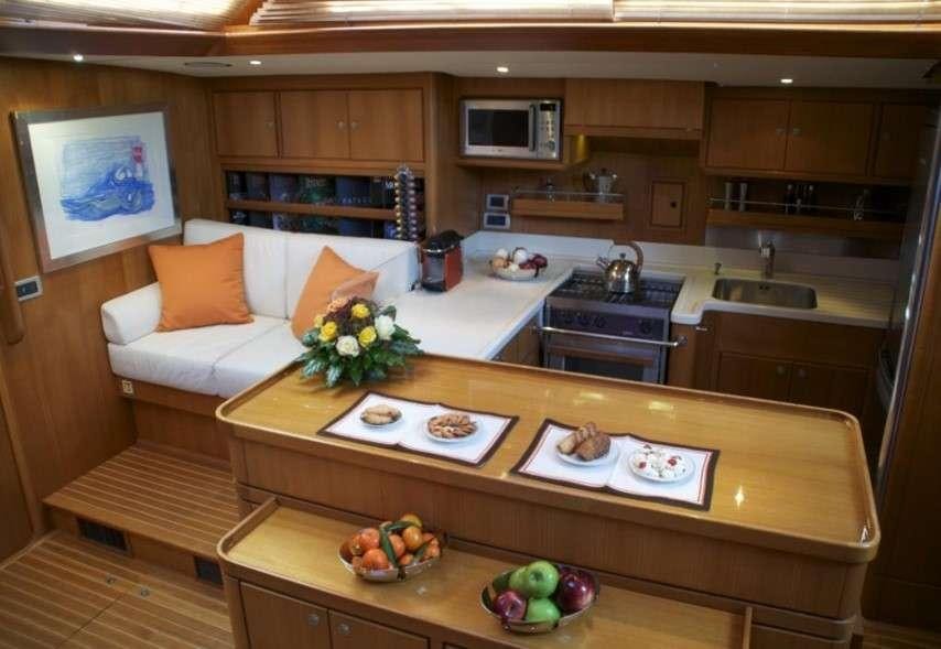 a kitchen with a table and a couch aboard VOLADOR Yacht for Charter