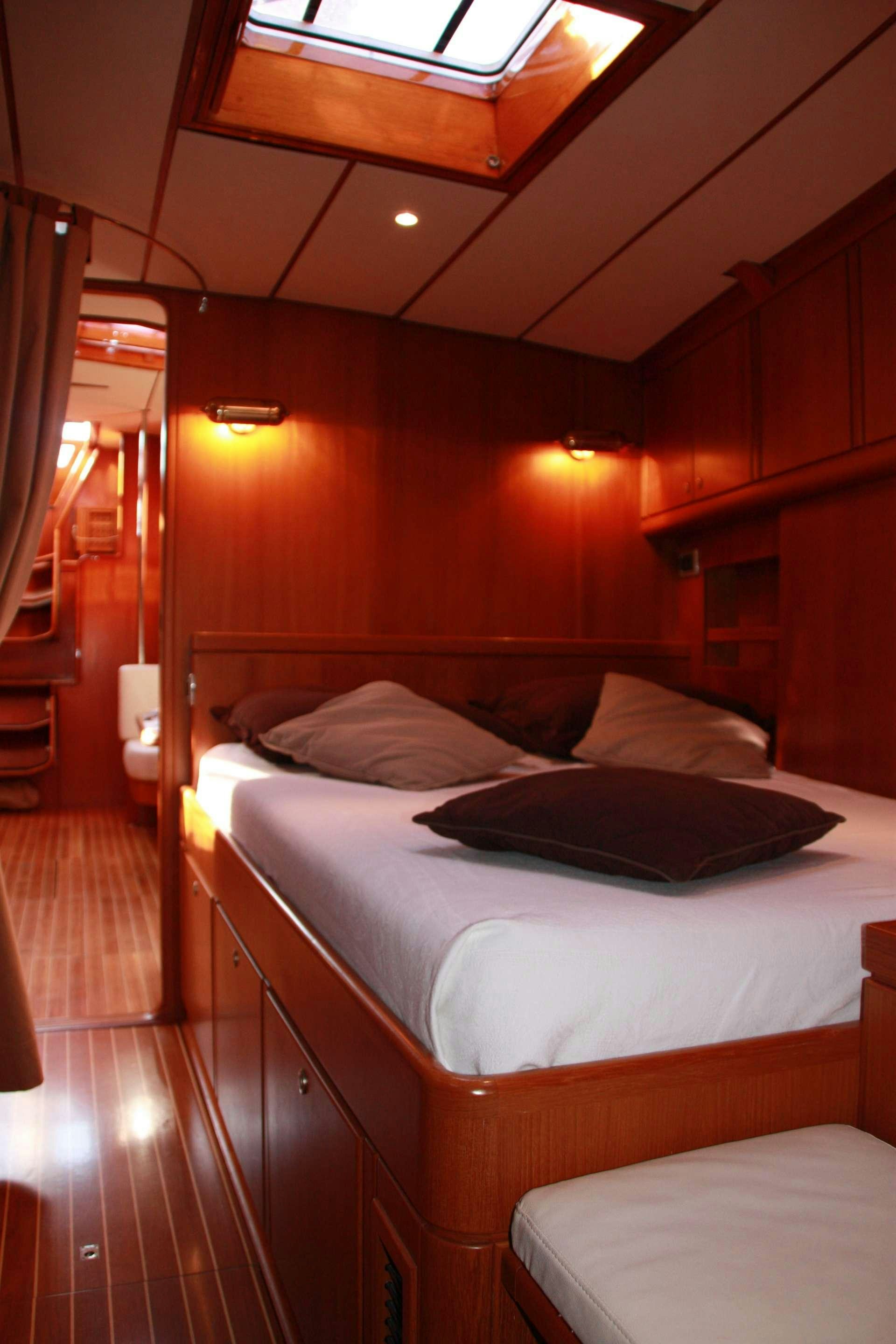 a room with a bed and a wood wall aboard VOLADOR Yacht for Charter