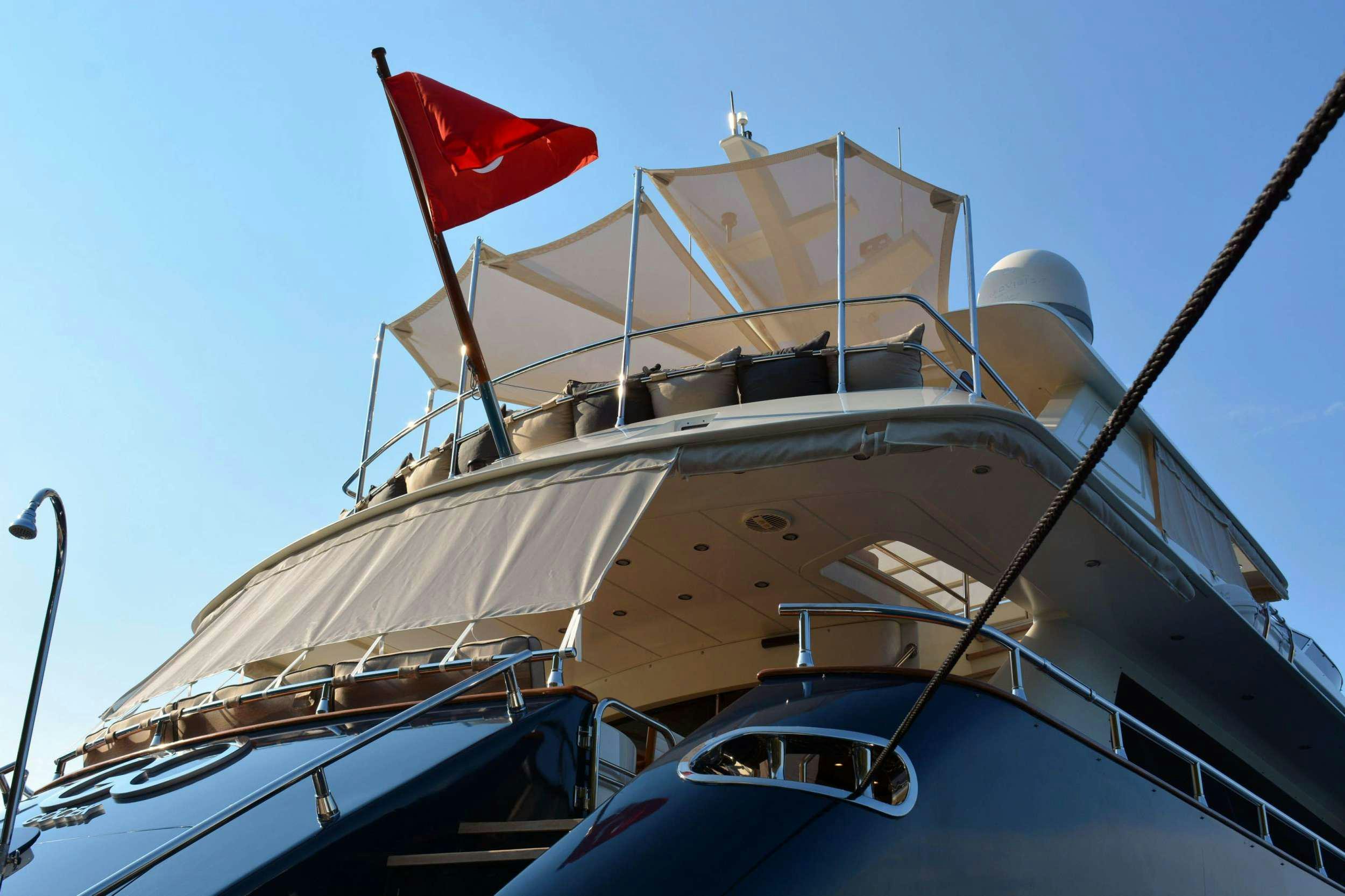 a large boat with a flag on top aboard GO Yacht for Charter
