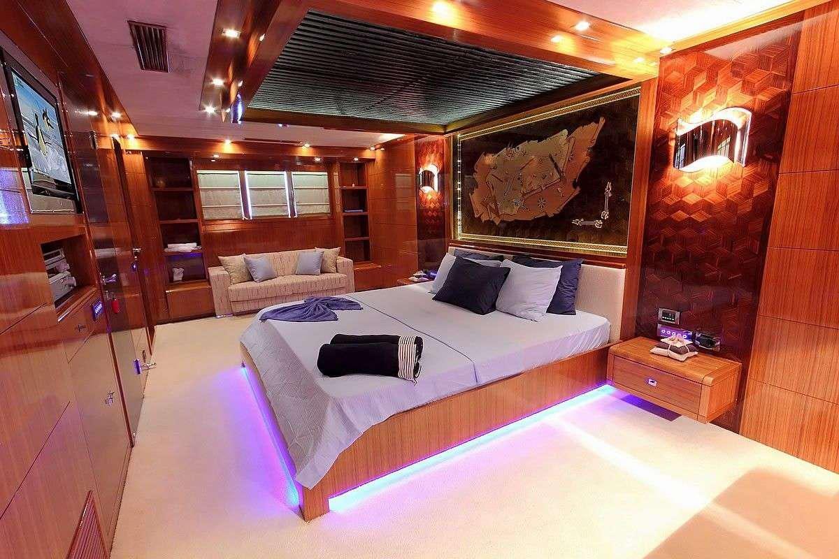 a room with a bed and a couch aboard GO Yacht for Charter