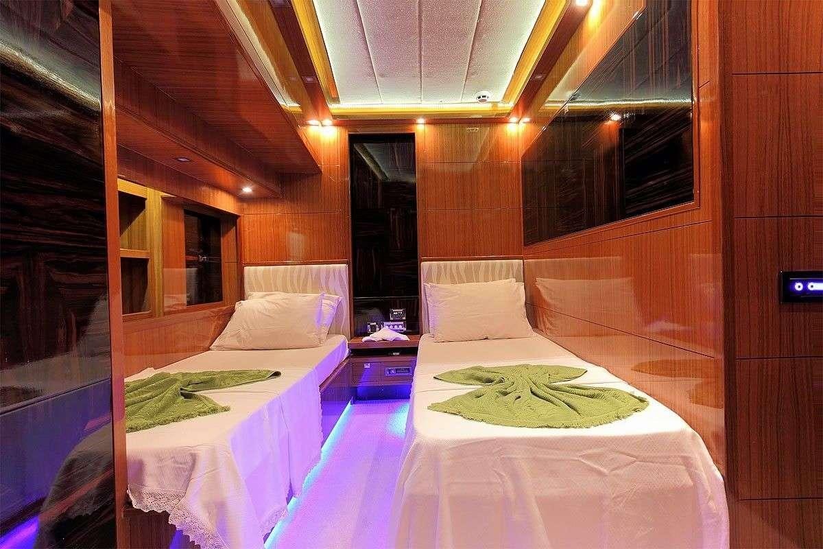 a room with a bed and a table aboard GO Yacht for Charter