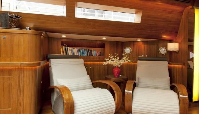 a room with a couch and a table and a clock aboard SILVERLINING Yacht for Charter