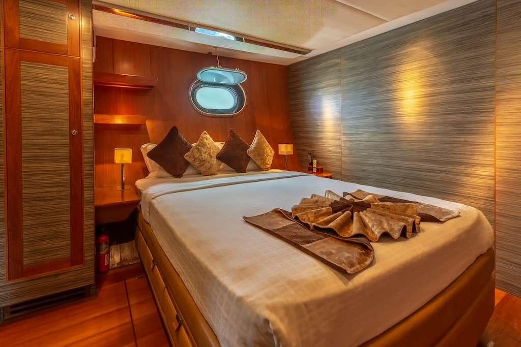 a bed with a white sheet and pillows on it aboard SILVERLINING Yacht for Charter