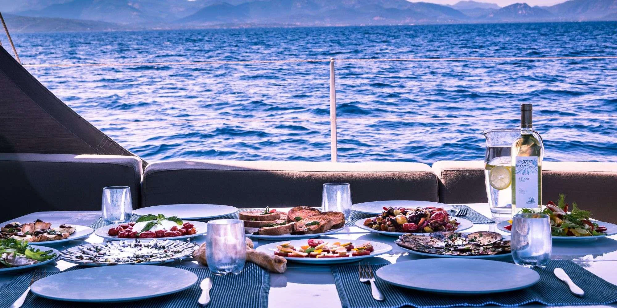 a table with food and drinks on it aboard IKIGAI Yacht for Charter