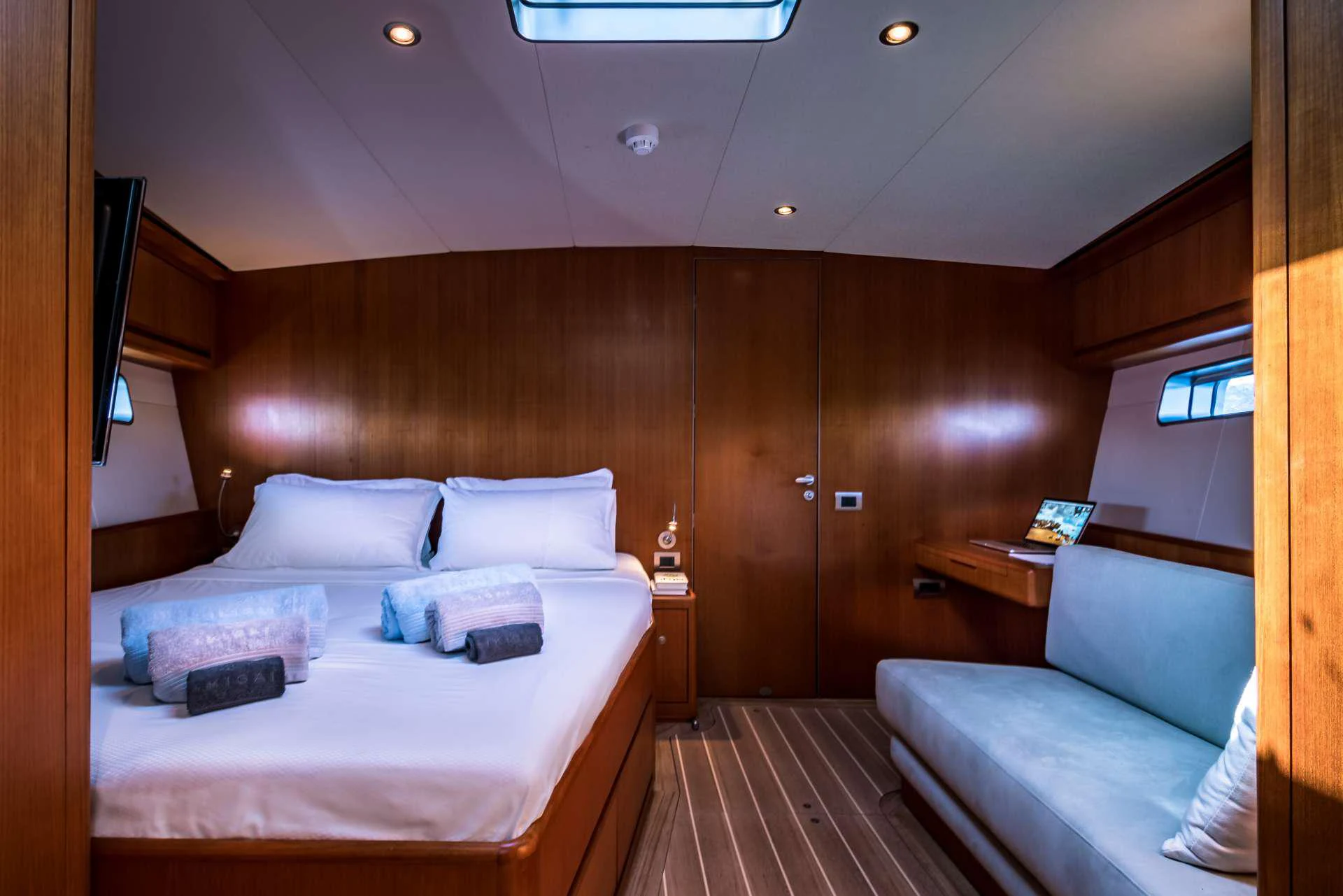 a room with a bed and a desk aboard IKIGAI Yacht for Charter