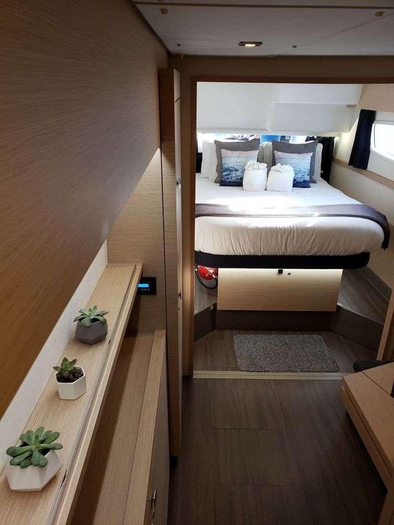 a room with a bed and a wood floor aboard Ghost Yacht for Charter