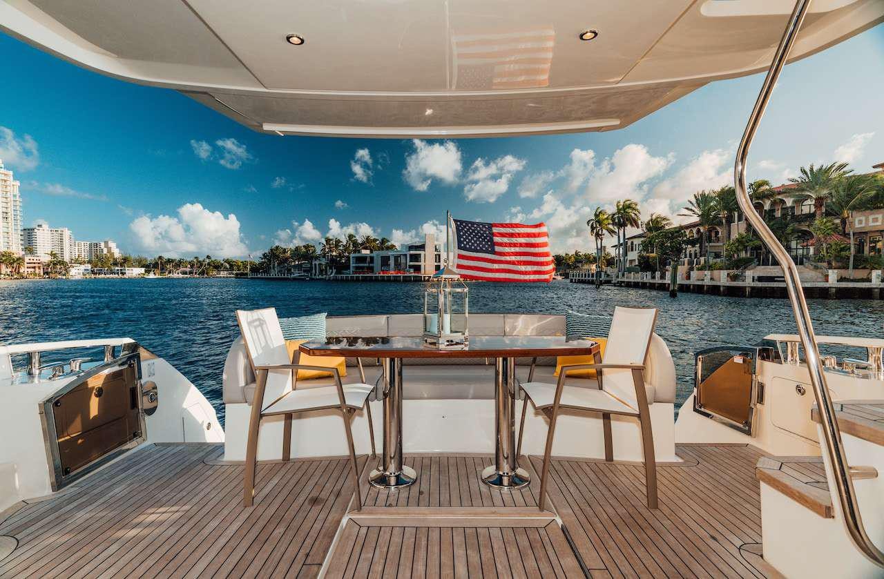 a table and chairs on a deck overlooking a body of water aboard KRAKEN Yacht for Charter