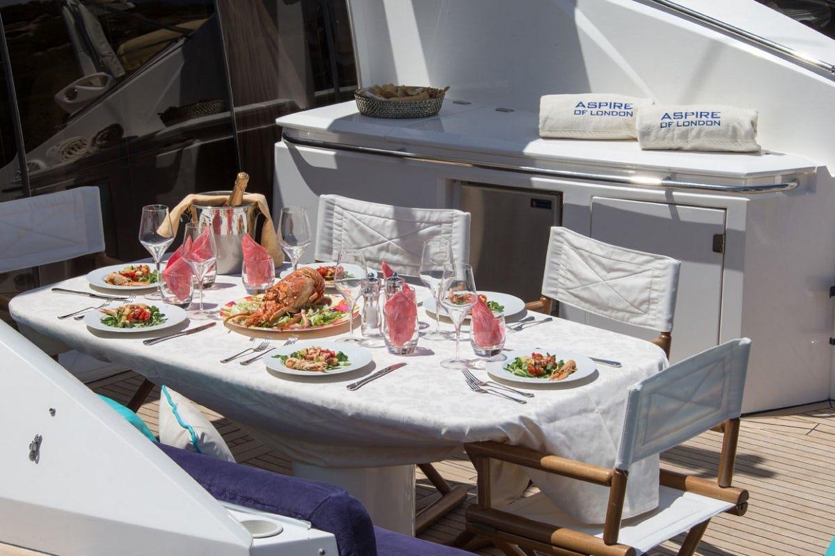 a table with plates of food and glasses on it aboard ASPIRE OF LONDON Yacht for Charter