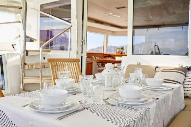 a table with plates and cups on it aboard BIG GANI Yacht for Charter