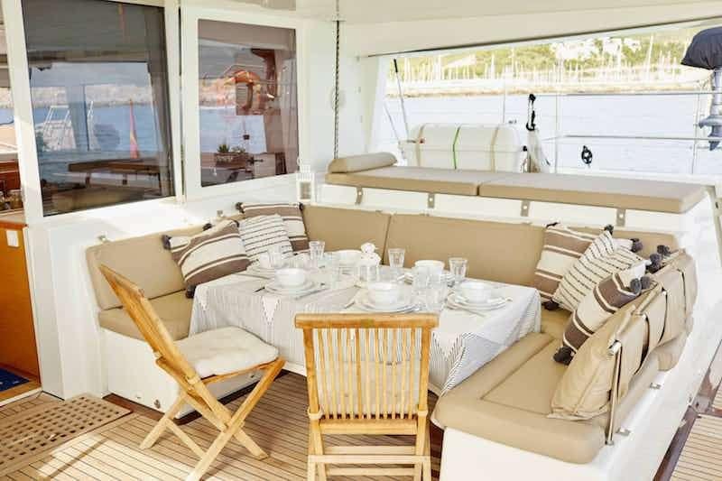 a room with a table chairs and a bed aboard BIG GANI Yacht for Charter