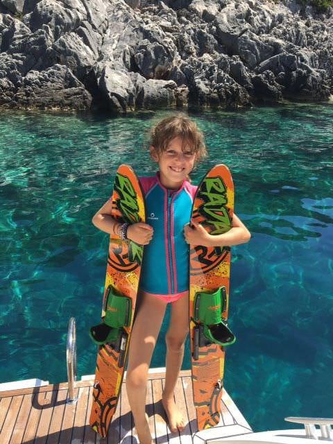 a boy holding a colorful snake aboard BIG GANI Yacht for Charter