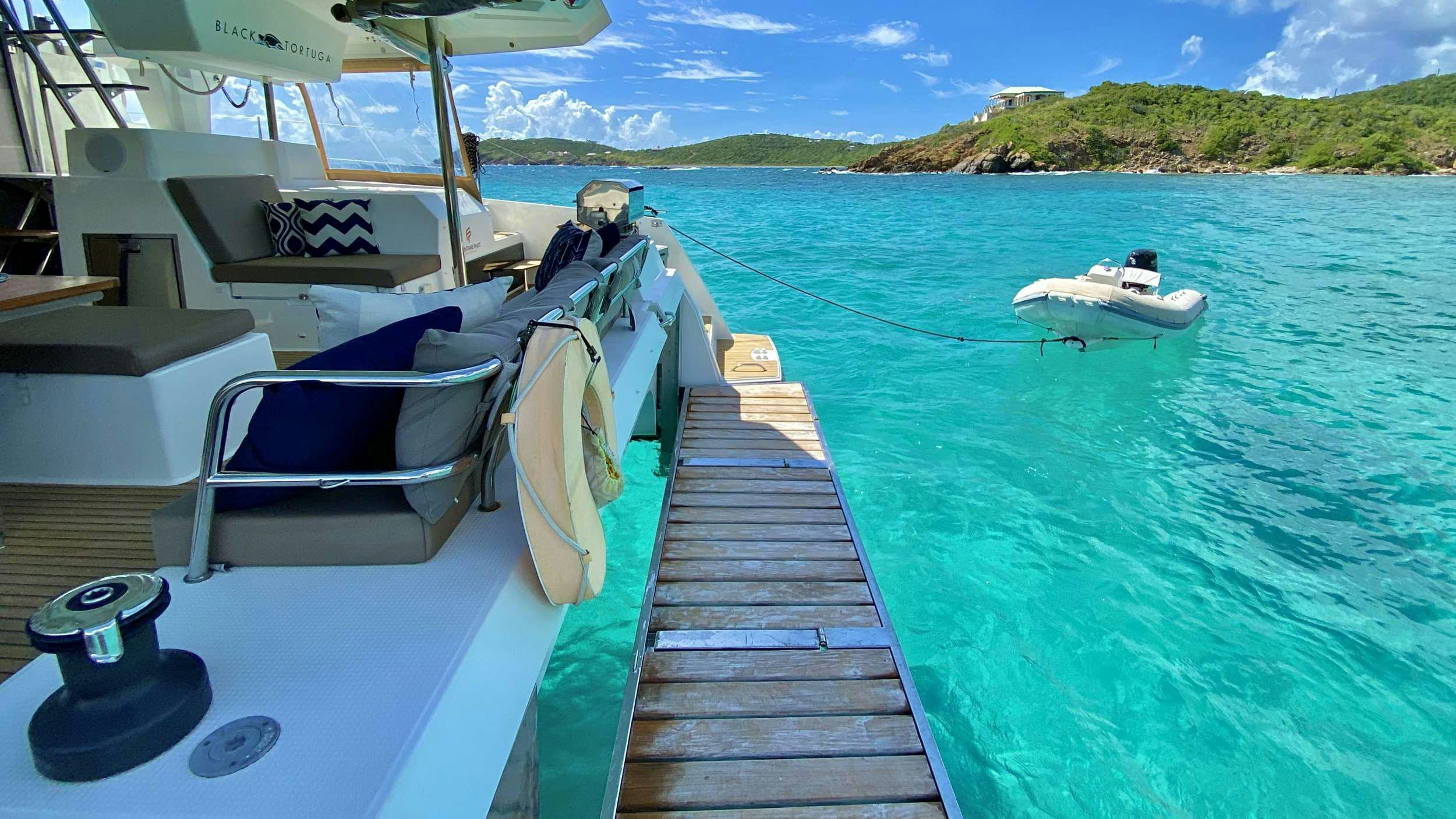 a boat dock with boats aboard BLACK TORTUGA Yacht for Charter