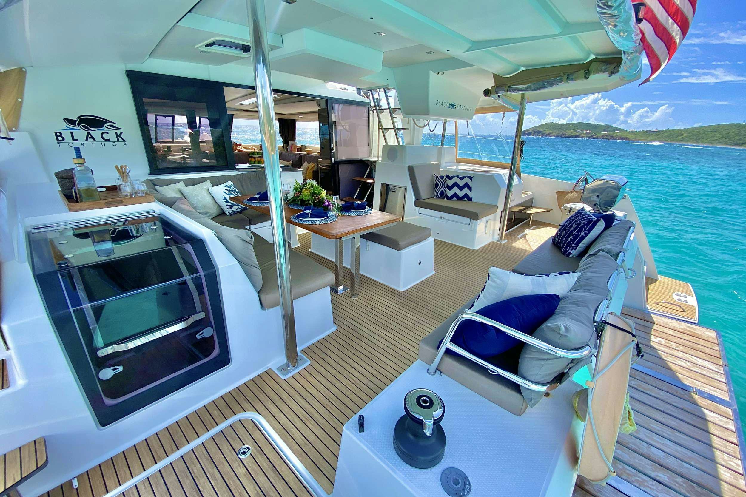 a boat with a table and chairs aboard BLACK TORTUGA Yacht for Charter