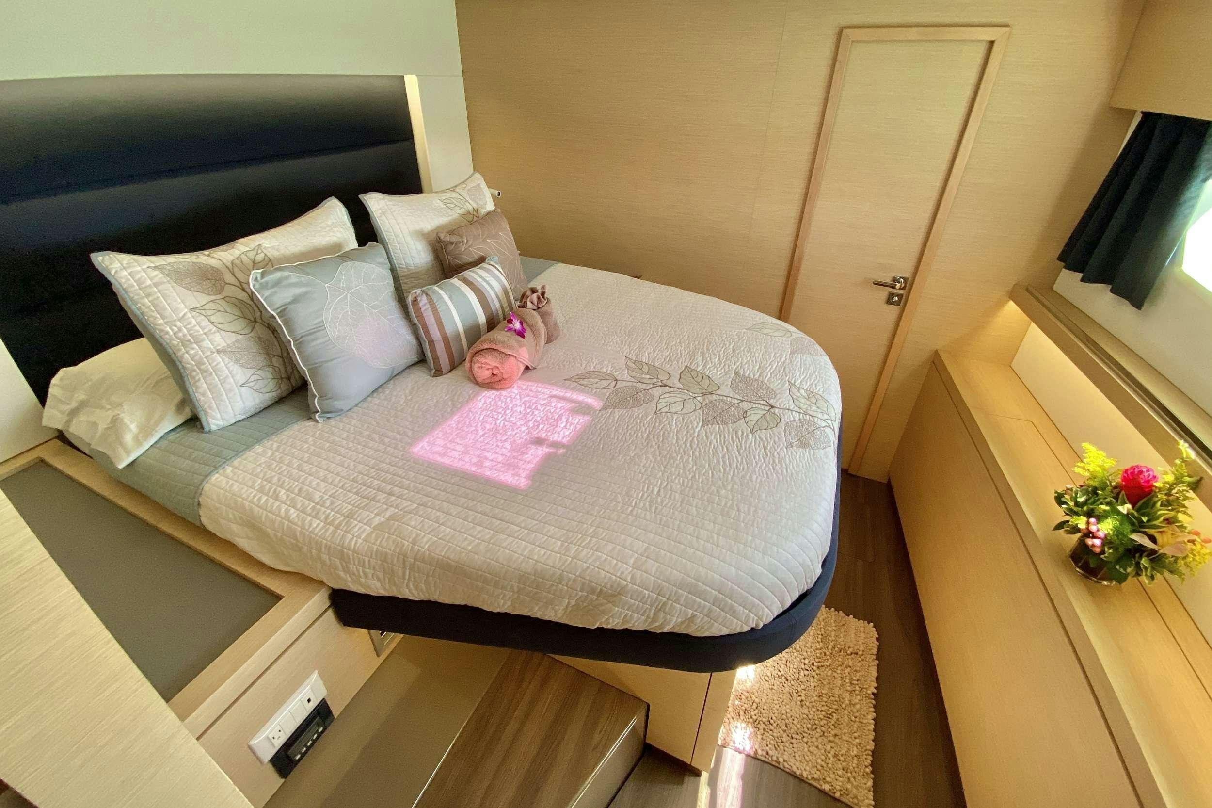 a bed with a pink pillow aboard BLACK TORTUGA Yacht for Charter