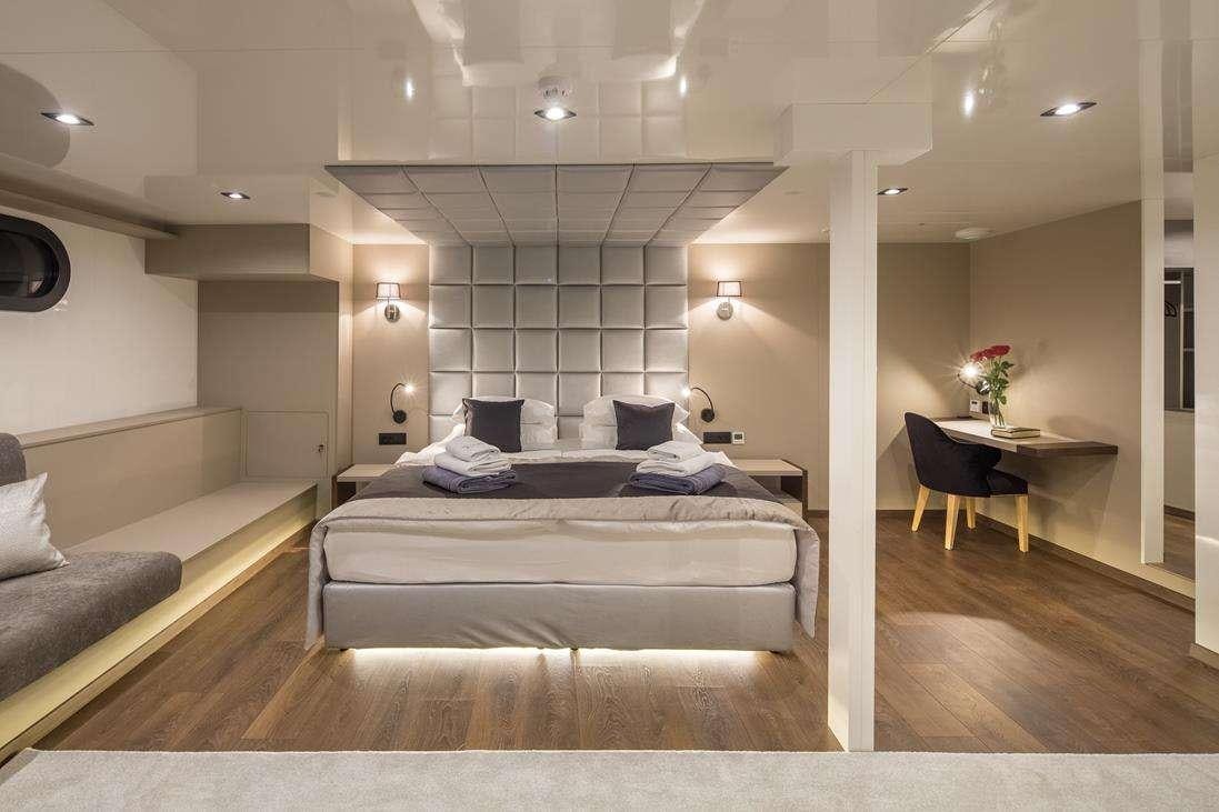 a room with a bed and a chair aboard RARA AVIS Yacht for Charter