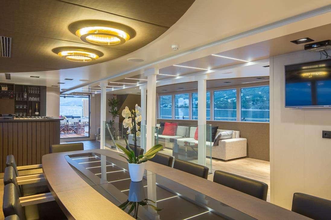 a room with a table and couches aboard RARA AVIS Yacht for Charter