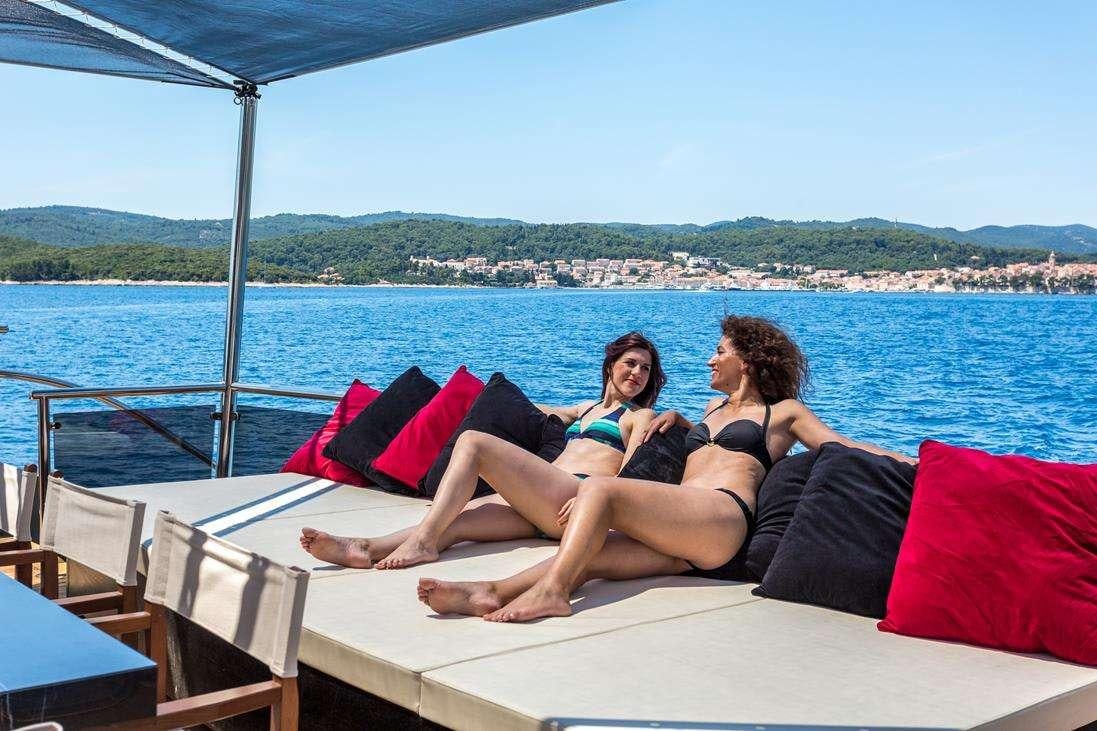 a group of people sitting on a boat aboard RARA AVIS Yacht for Charter