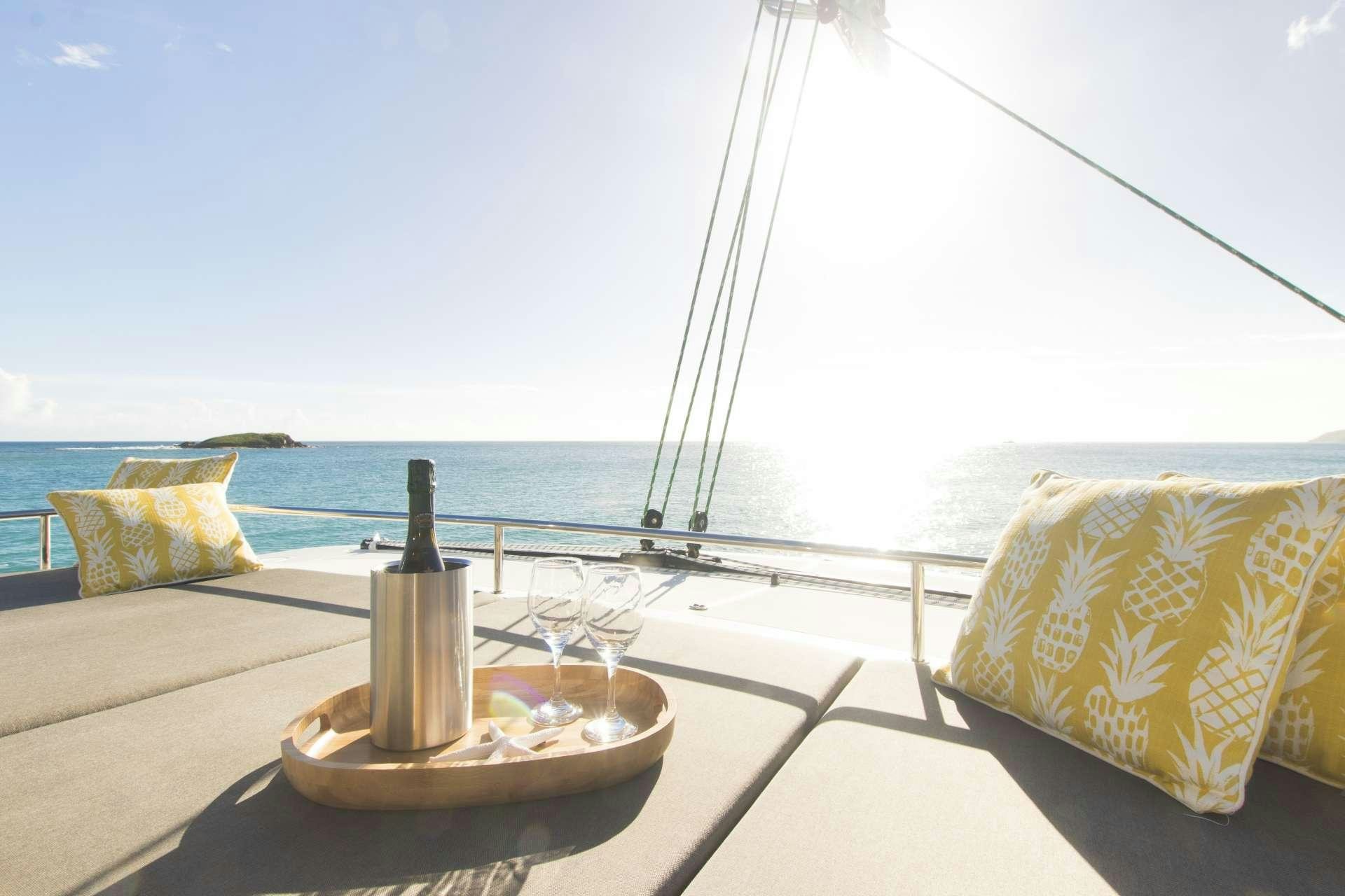 a glass table with a glass vase and a bottle on it aboard RUMBA Yacht for Charter