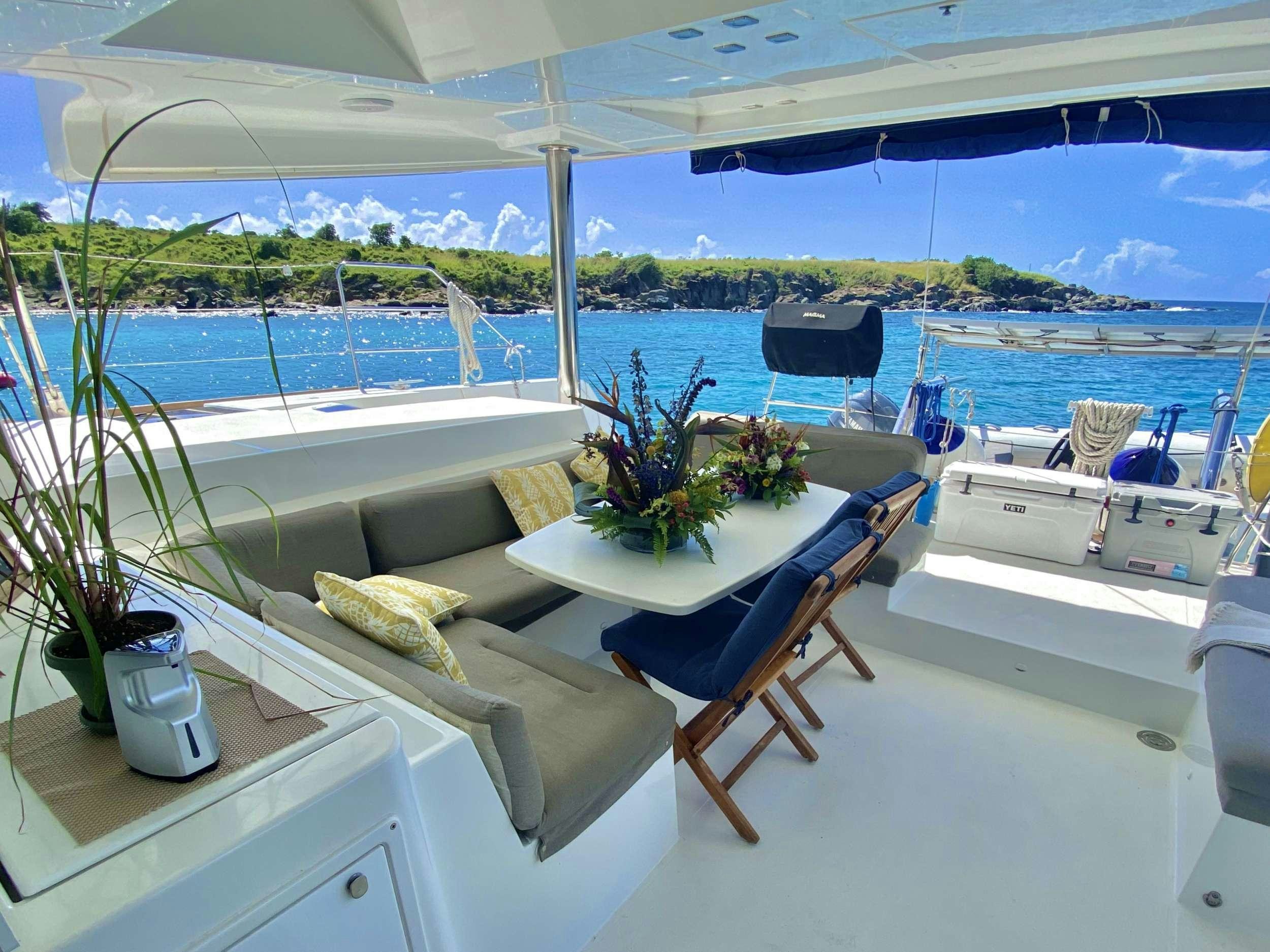 a table with chairs on it next to a large body of water aboard RUMBA Yacht for Charter