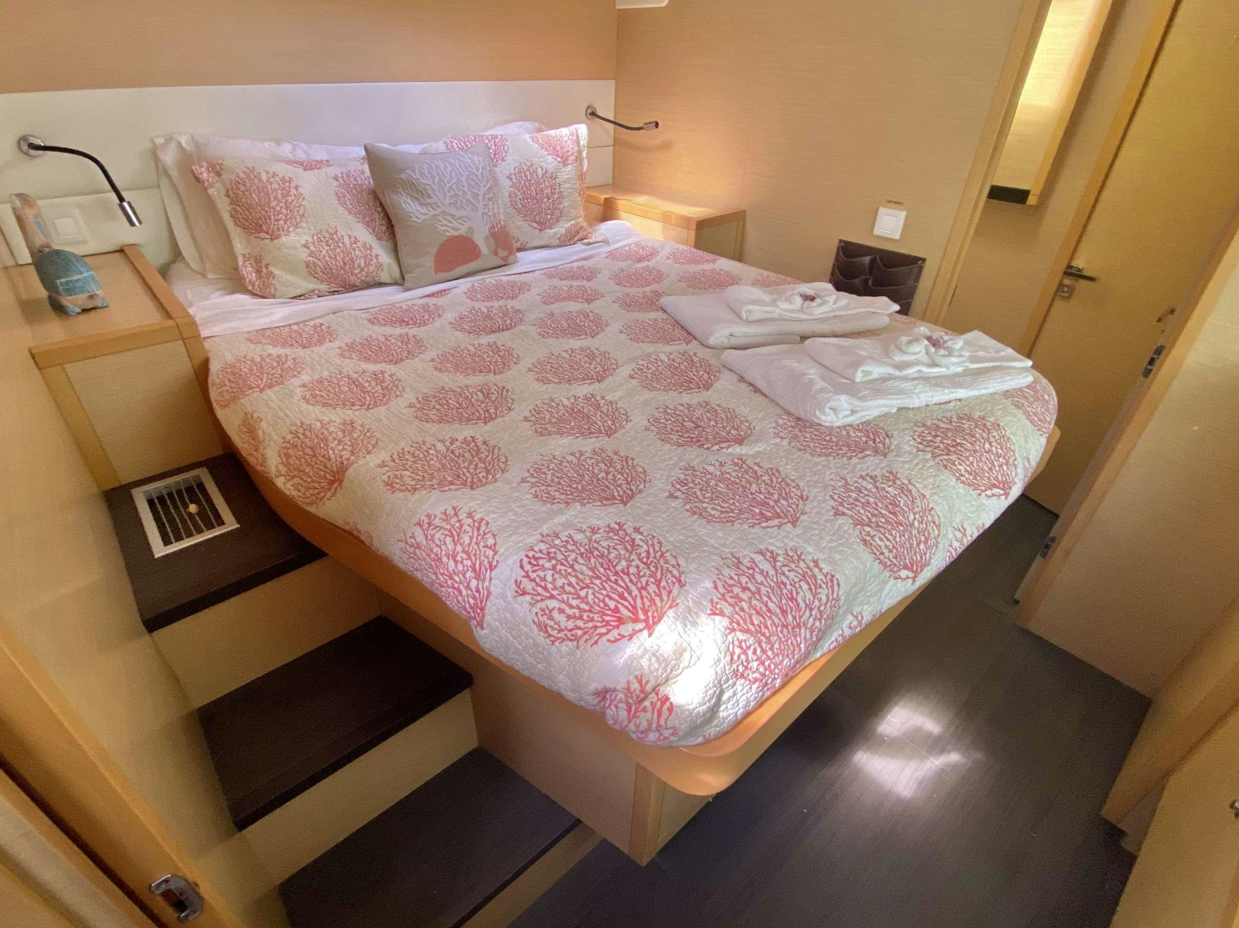 a bed with pink and white sheets aboard RUMBA Yacht for Charter
