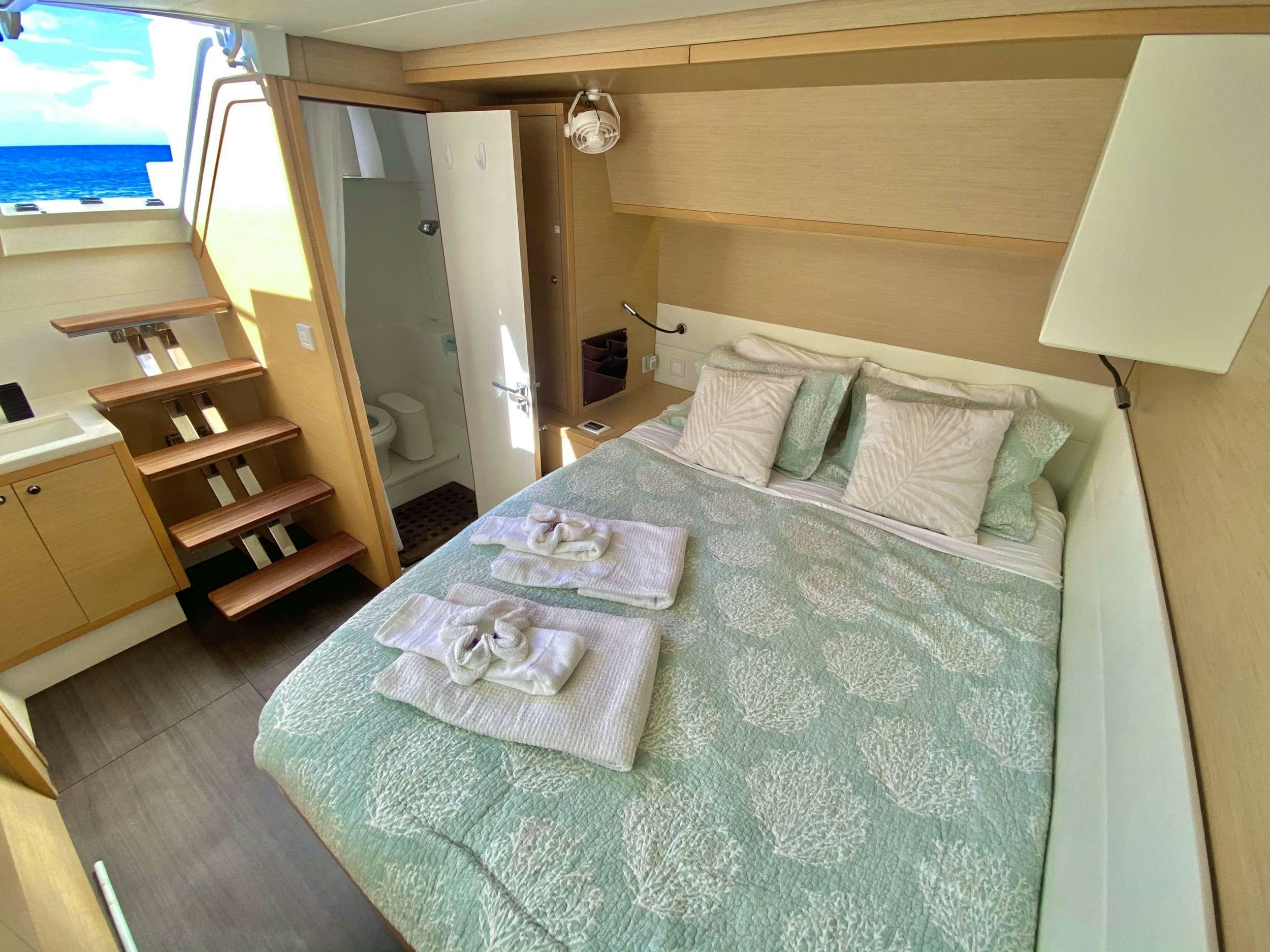 a bed with a blue sheet aboard RUMBA Yacht for Charter