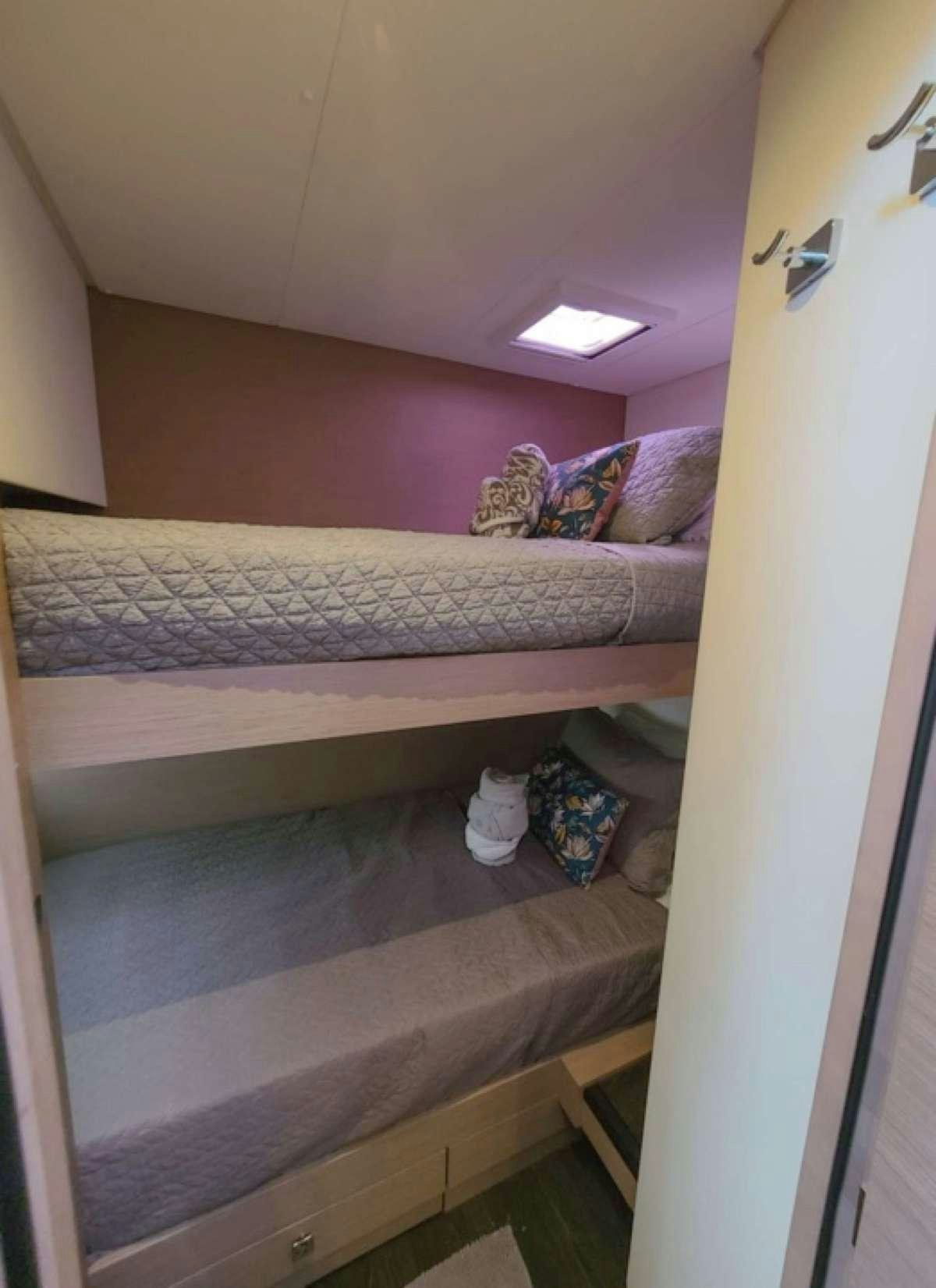 a bed with a white bed spread aboard CHAMPS ELYSEES Yacht for Charter