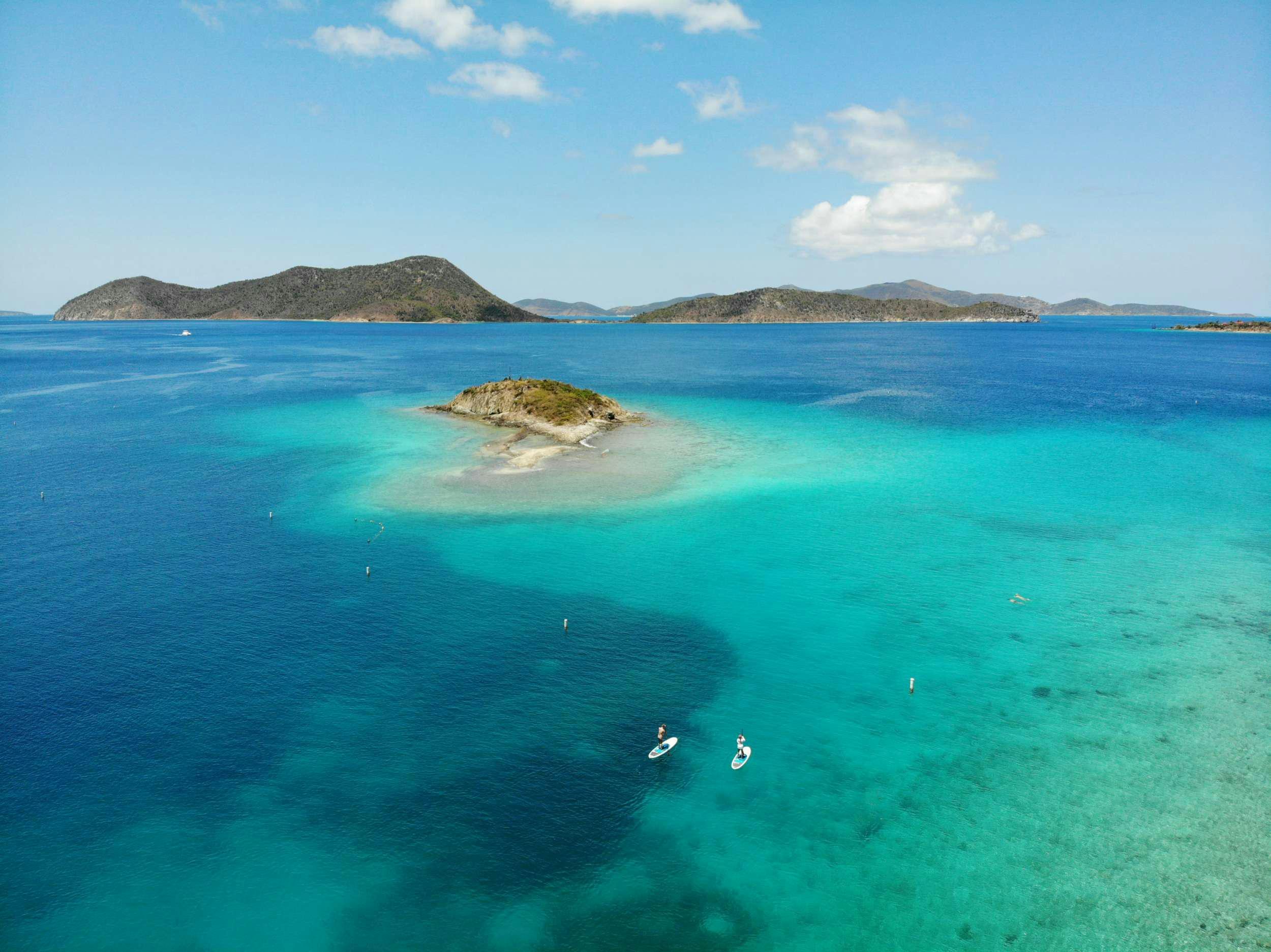 a body of water with a rocky island in the distance aboard CHAMPS ELYSEES Yacht for Charter