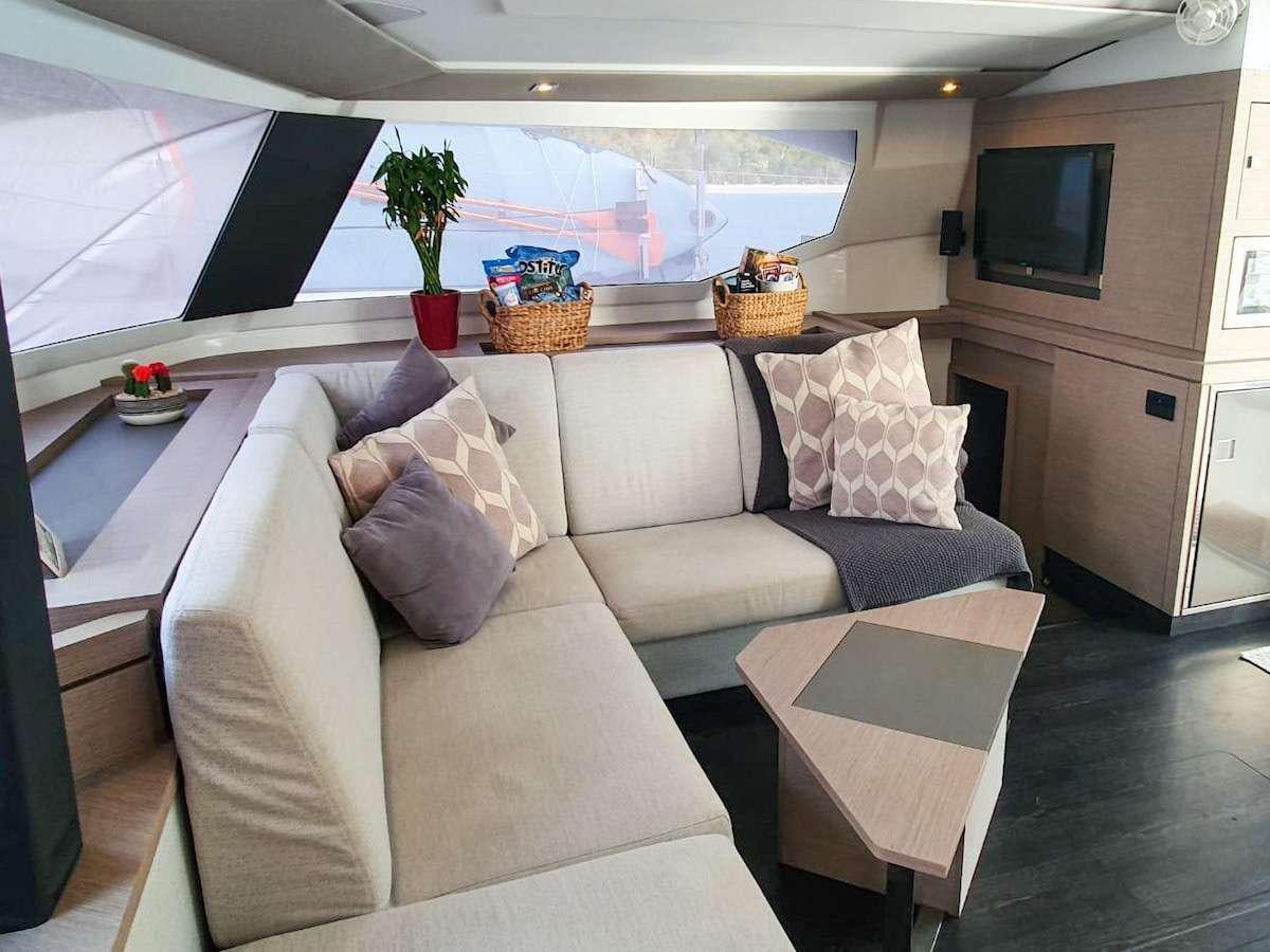 a living room with a couch and a television aboard CHAMPS ELYSEES Yacht for Charter