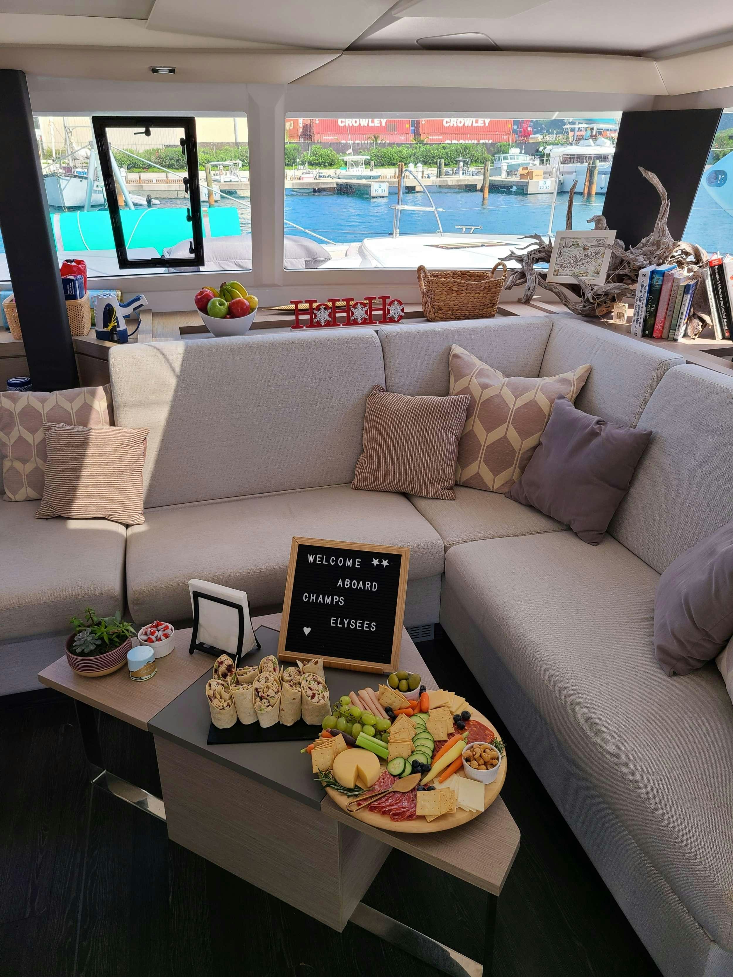 a couch with a table and a plate of food on it aboard CHAMPS ELYSEES Yacht for Charter