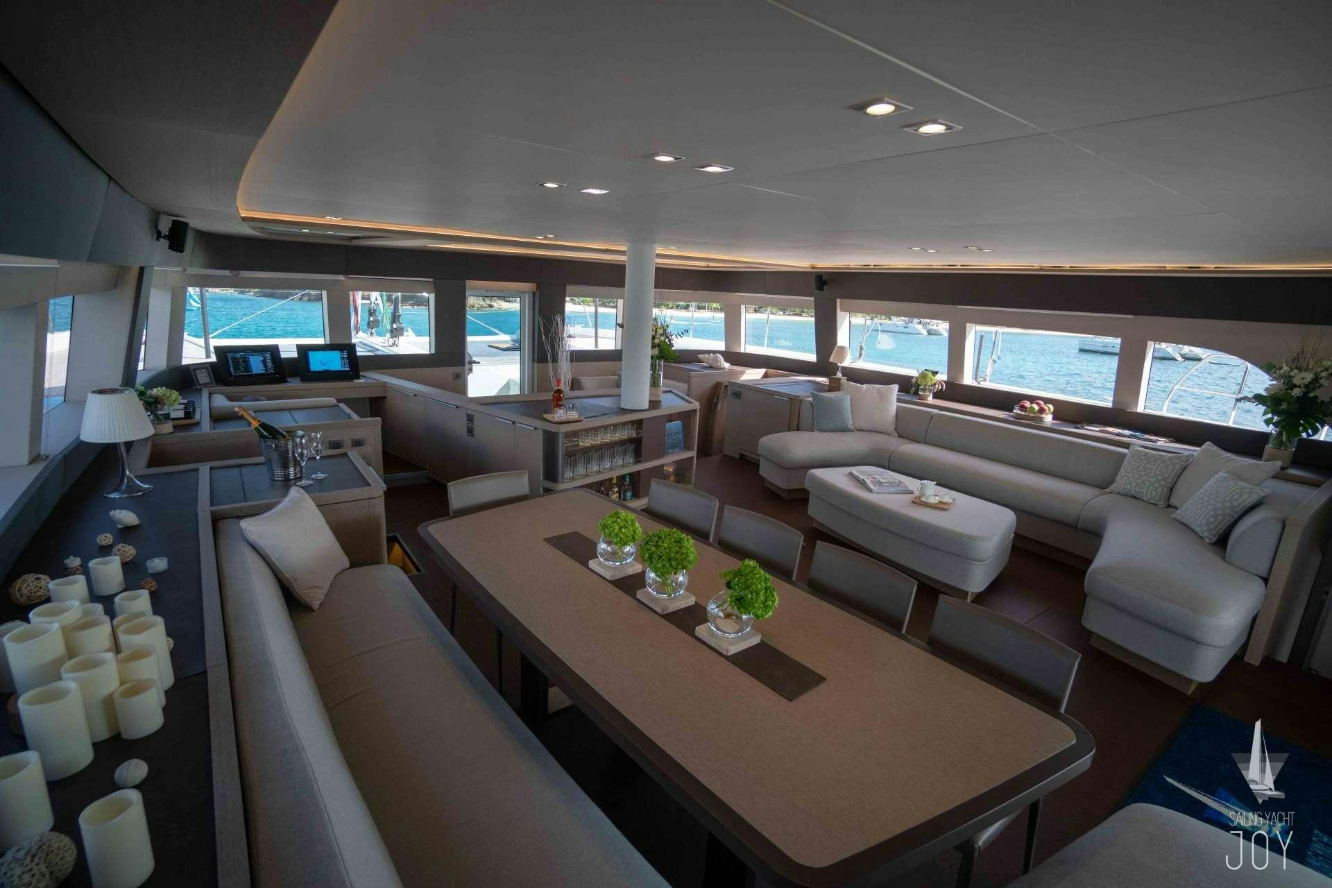 a living room with a large table and chairs aboard JOY Yacht for Charter