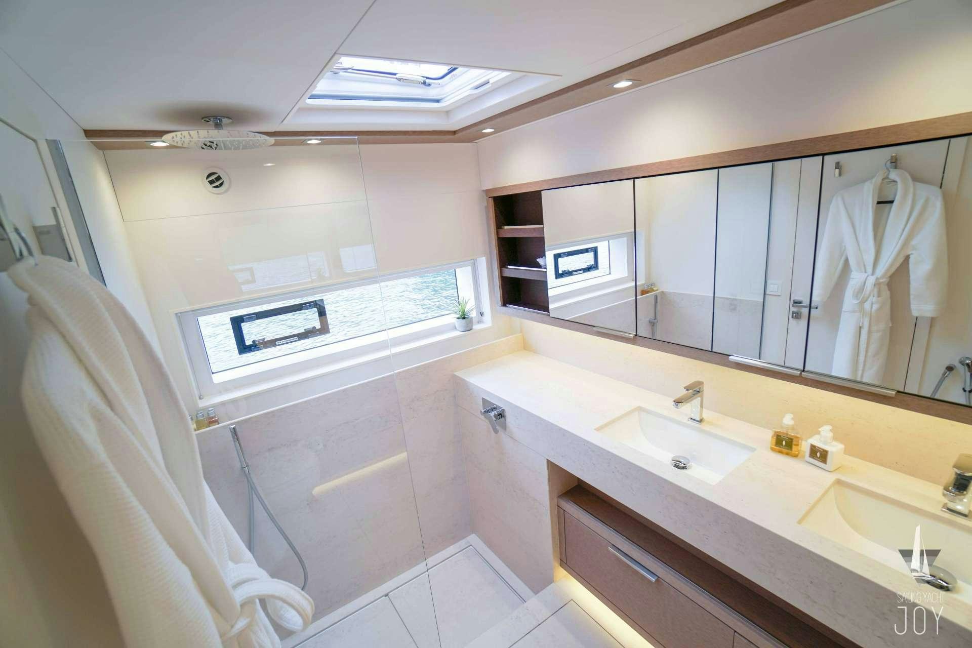 a bathroom with a large mirror aboard JOY Yacht for Charter