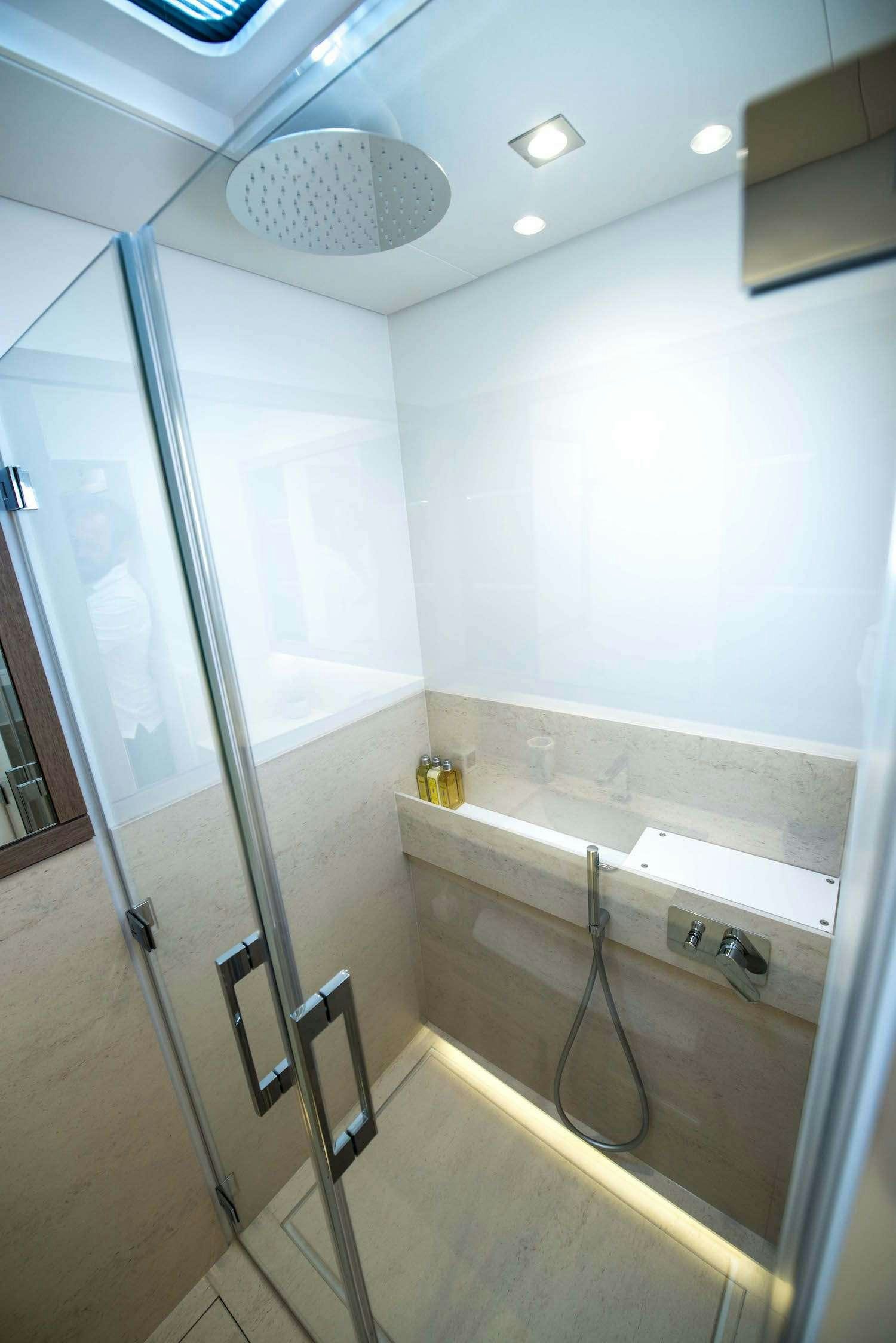 a bathroom with a glass shower aboard JOY Yacht for Charter