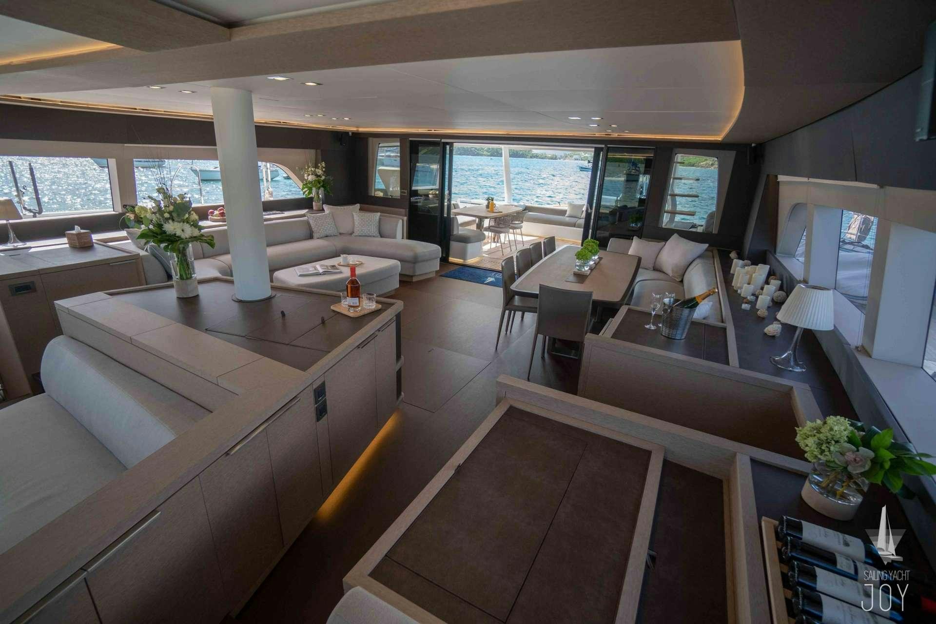 a large room with a table and chairs aboard JOY Yacht for Charter