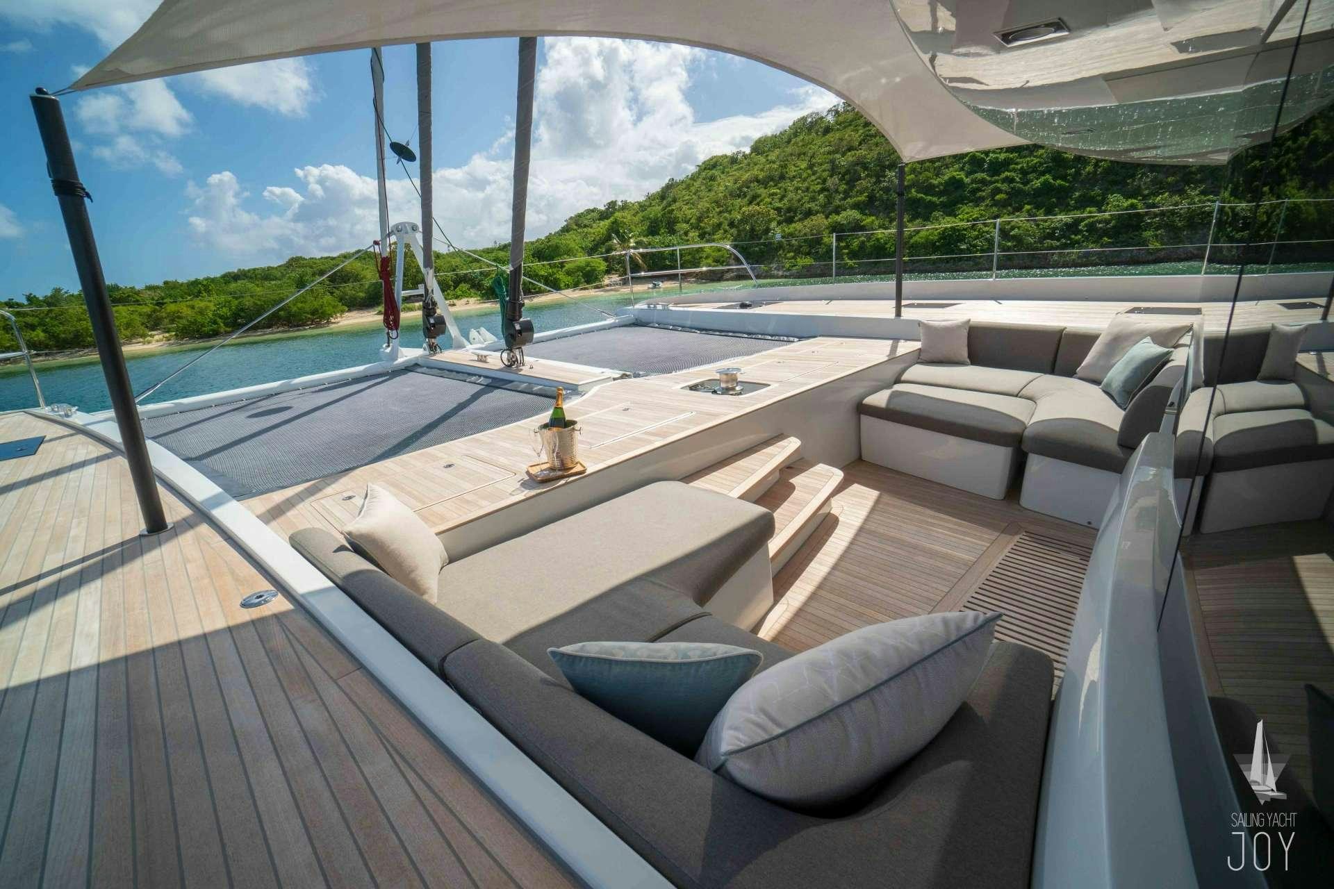 a deck with a view of the water and the beach aboard JOY Yacht for Charter