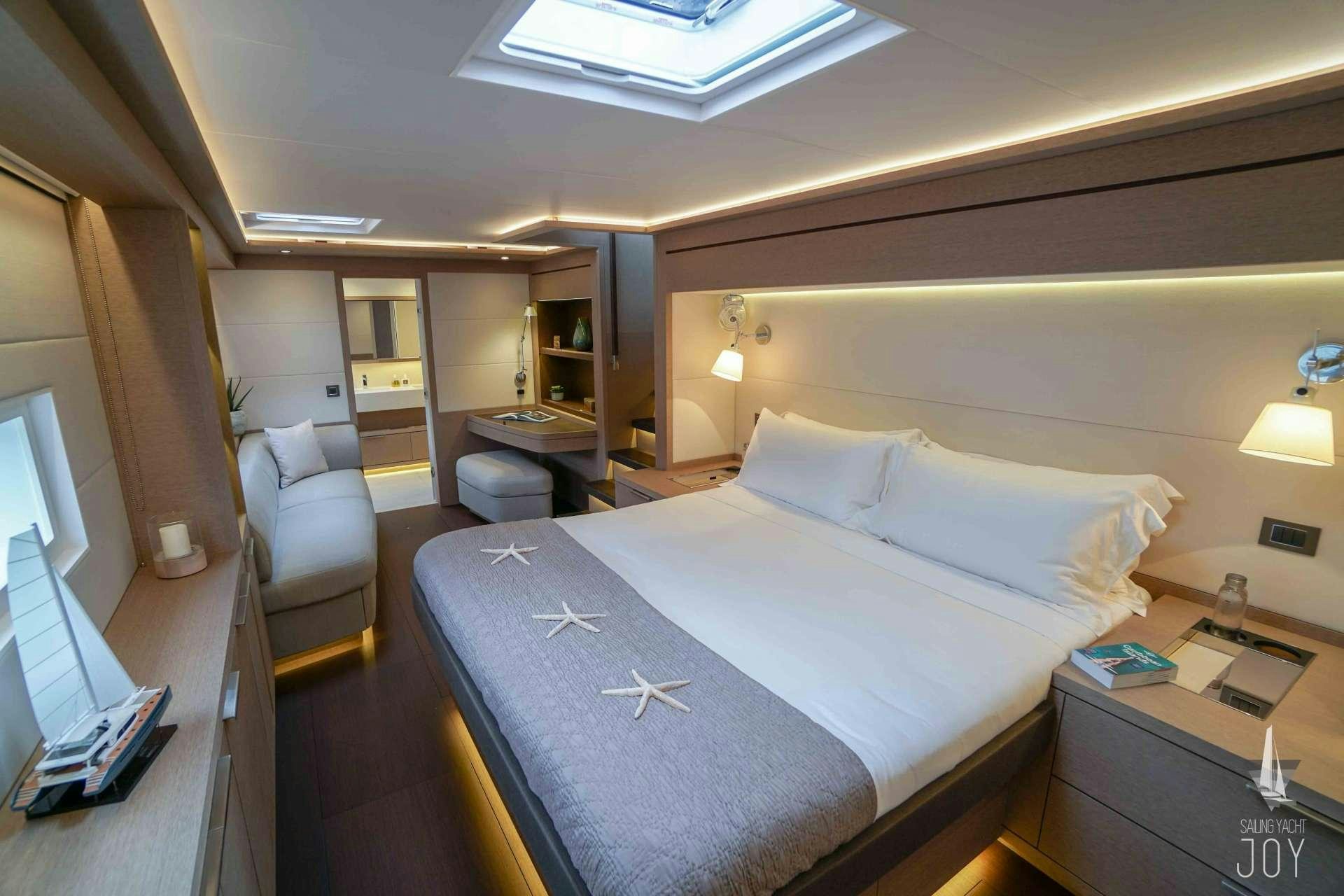 a hotel room with a bed and a chair aboard JOY Yacht for Charter