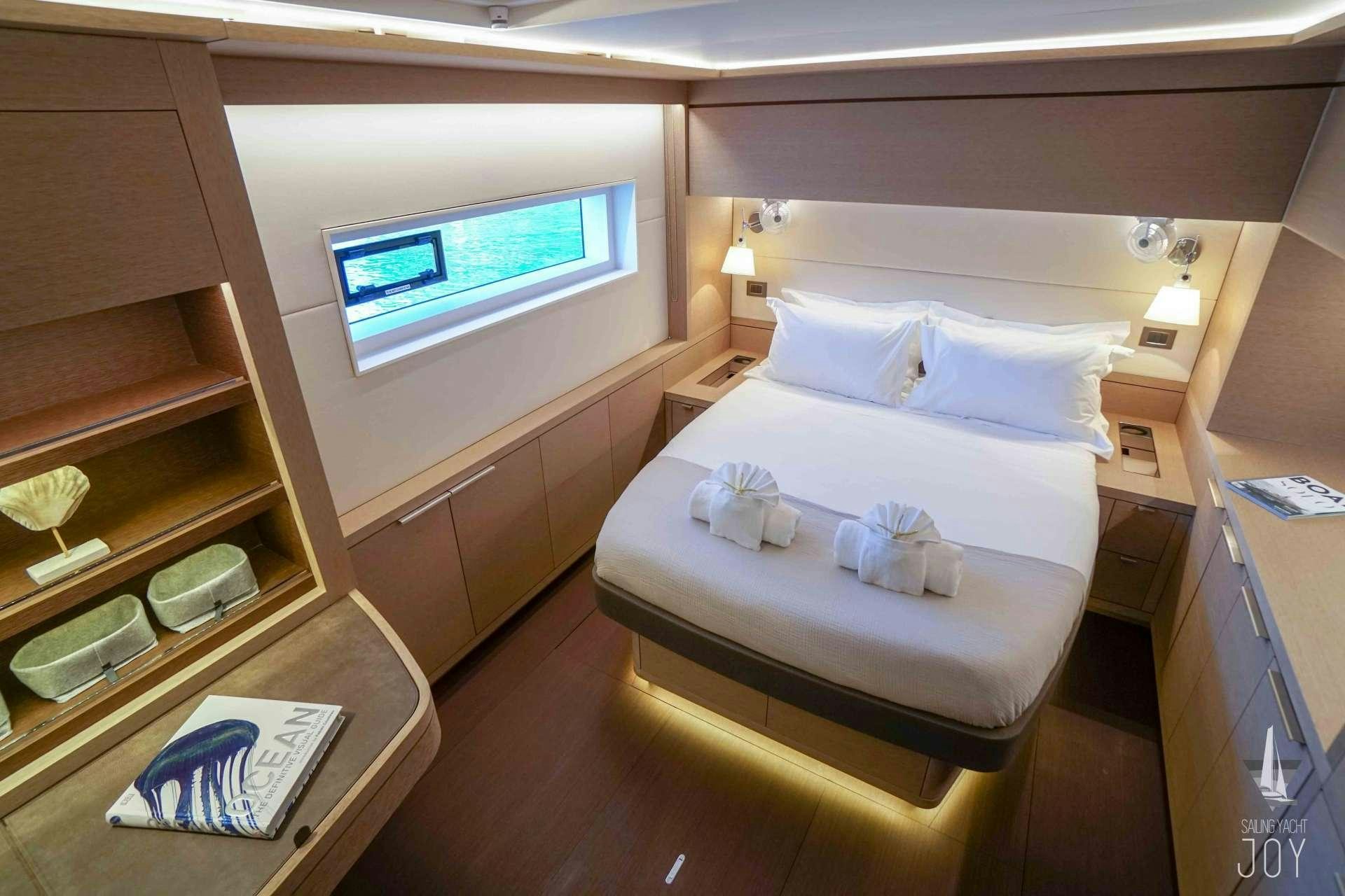 a room with a bed and a book on the floor aboard JOY Yacht for Charter