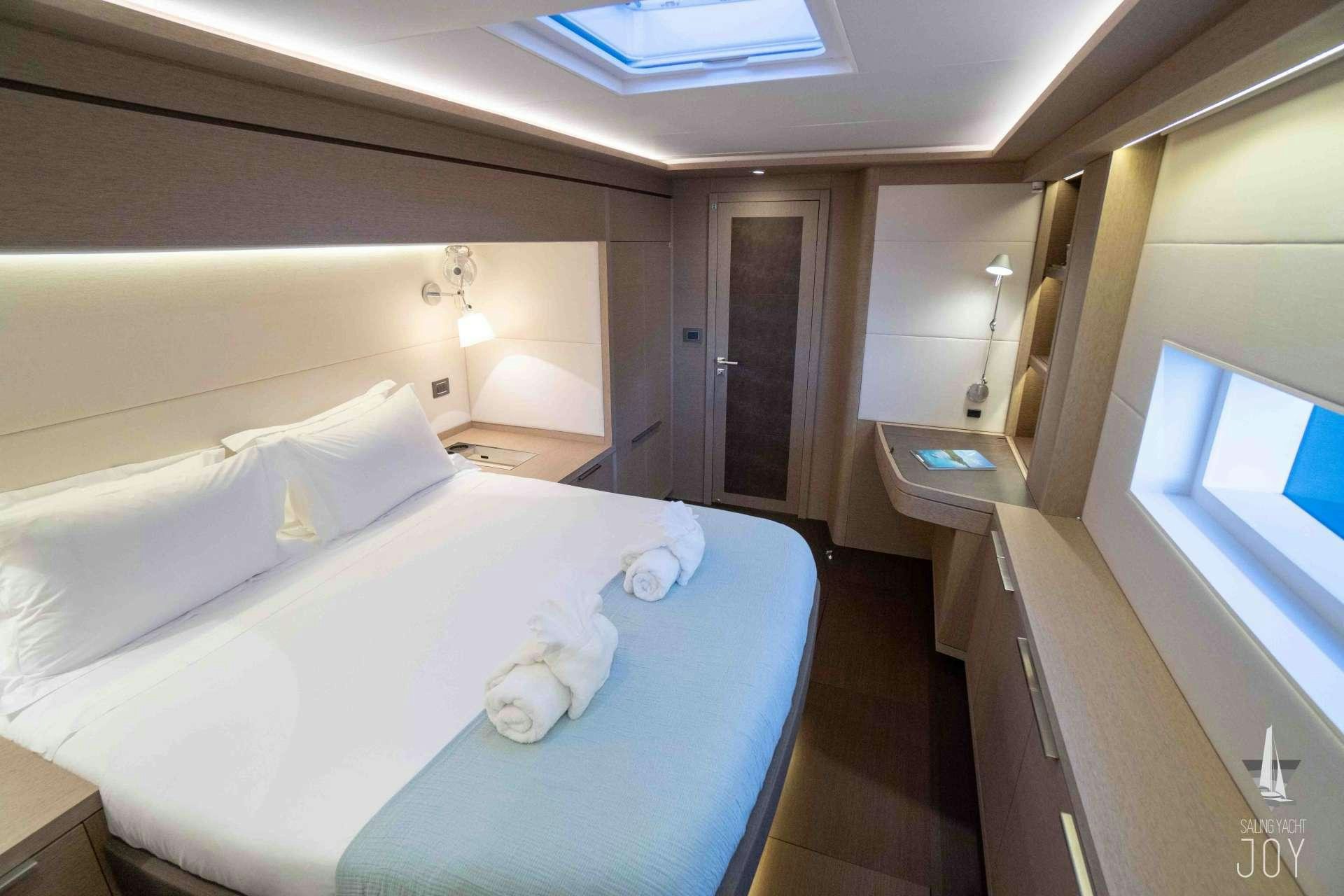 a bedroom with a bed and a desk aboard JOY Yacht for Charter