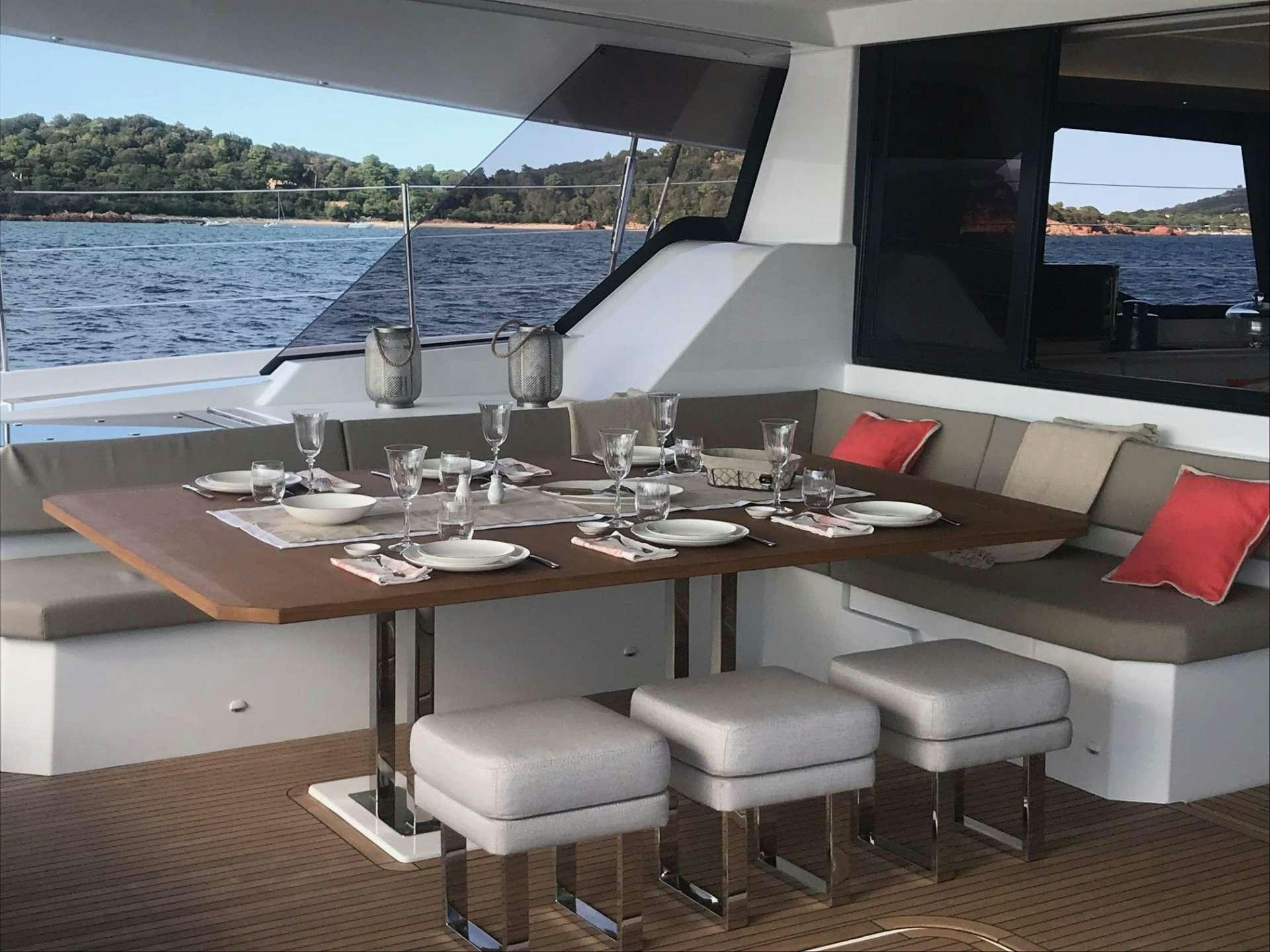 a table with chairs and a view of the water aboard AETHER Yacht for Charter